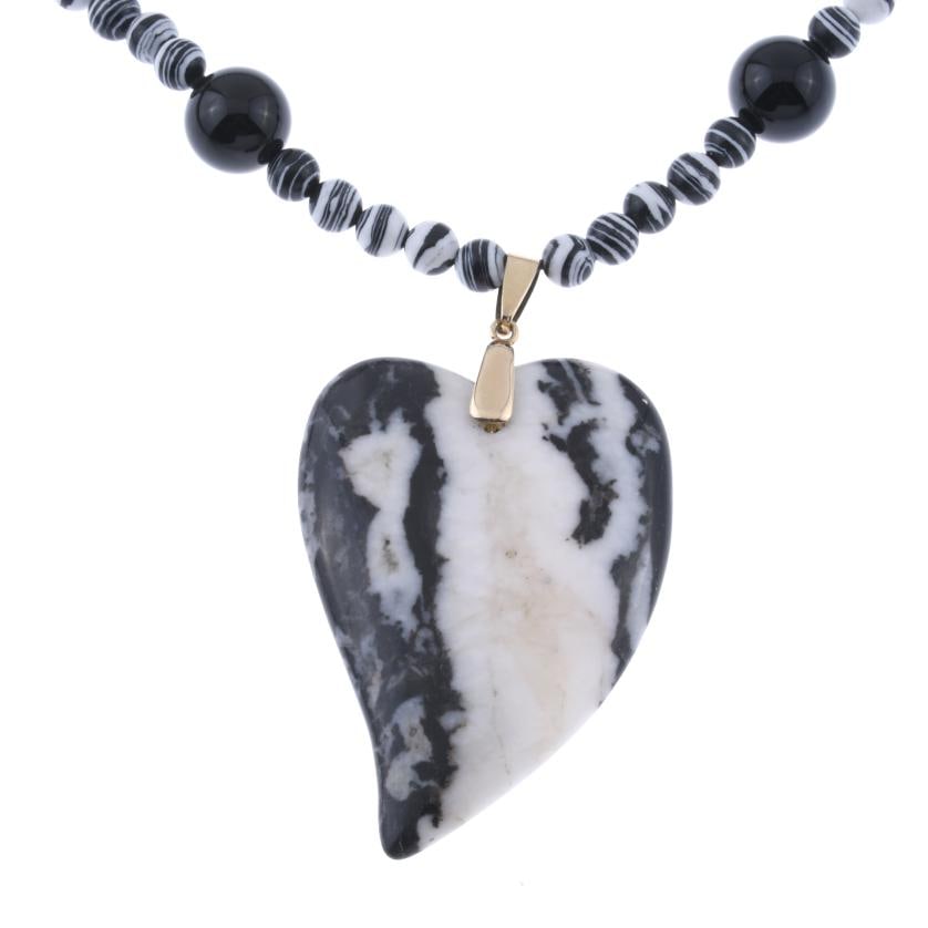 NECKLACE WITH ZEBRA-PATTERNED ONYX.: Made up of spherical beads and a heart-shaped pendant. Length: 29 cm.