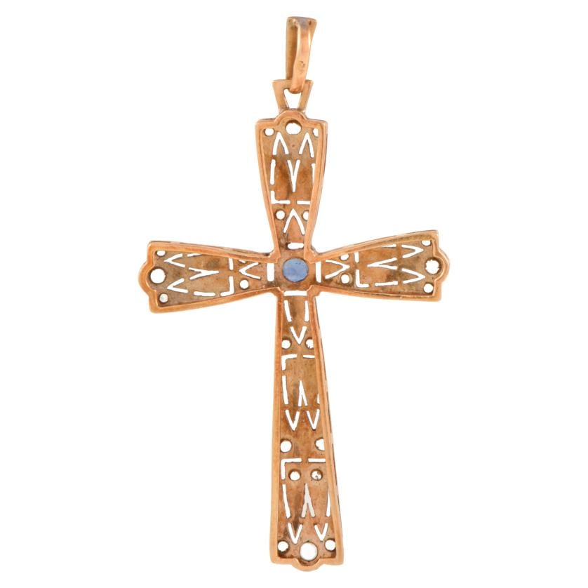 Modernist pendant cross: 18 kt yellow gold with platinum accents.Old cut white sapphires and a brilliant cut central sapphire.Weight: 2.1 gr.