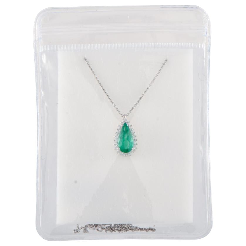 Necklace with emerald pendant surrounded by diamonds.: 18kt white gold.Pear cut emerald, 0.99 ct.Links chain with carabiner clasp.IGE certificate.