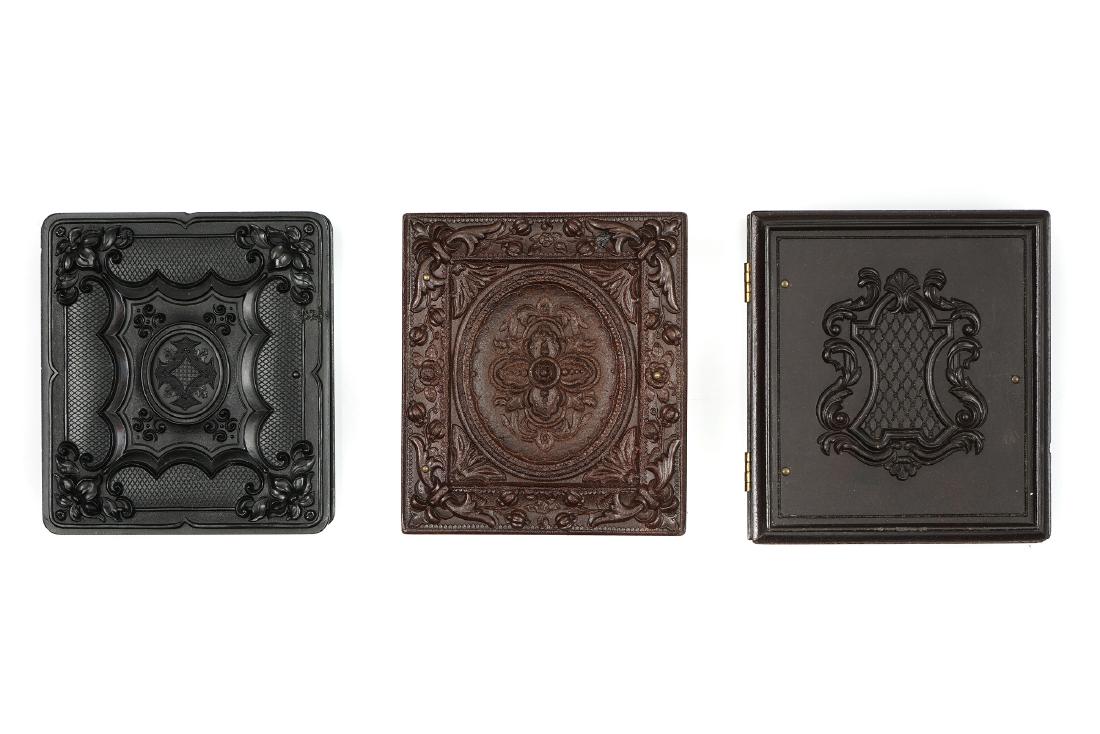 Three Union Cases with Ambrotypes,: one by Holmes, Booth & Hayden, with geometric scrolls, c.1860, 8.5cm x 9.5cm sixth-plate ambrotype of couple; one by A P Critchlow & Co., The Church Window, before 1858, 9.7cm x 8.7cm, sixth-plate amb