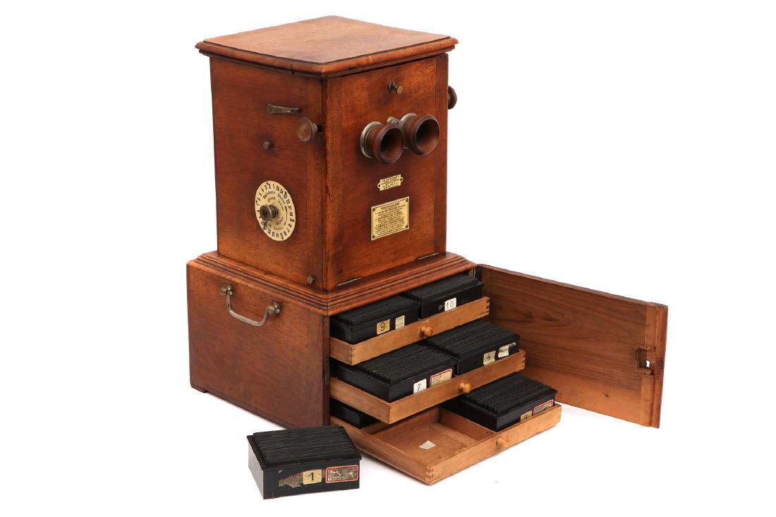 A Table Top Taxiphote Stereo Viewer,: French, C.1910, with plaque that reads 'Le Taxiphote' with instructions on a second plaque, drawer at bottom opens to reveal a large collection of stereo glass posotives in Taxiphote carriages, stero 