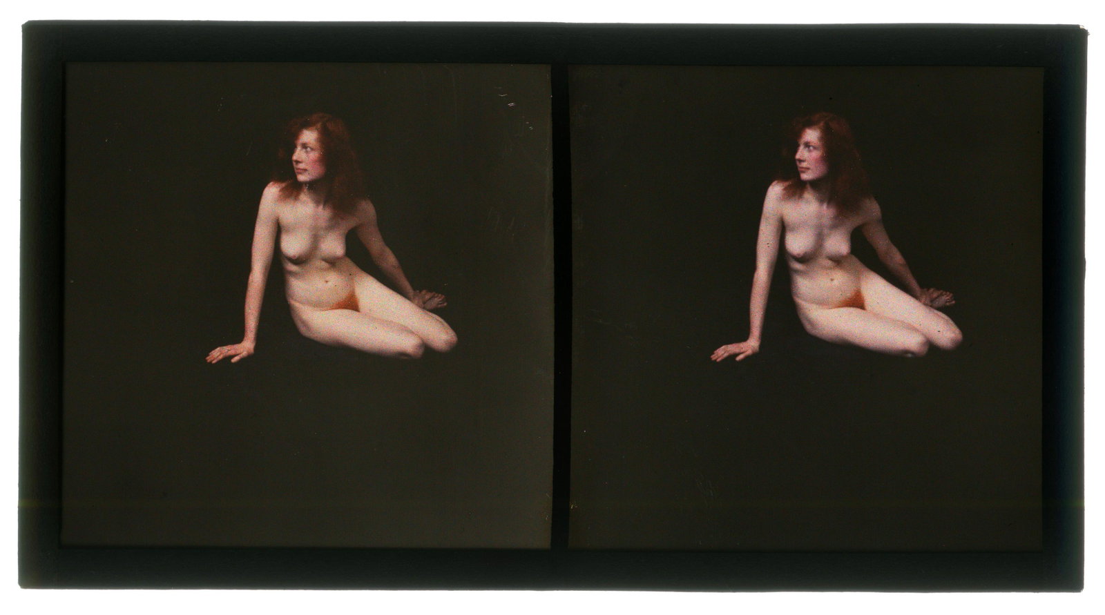 An Erotic Autochrome Stereoview,: c.1920, colour glass plate images of semi-reclining nude with auburn hair, seated on the floor, front view, 12.9cm x 6.8cm overall