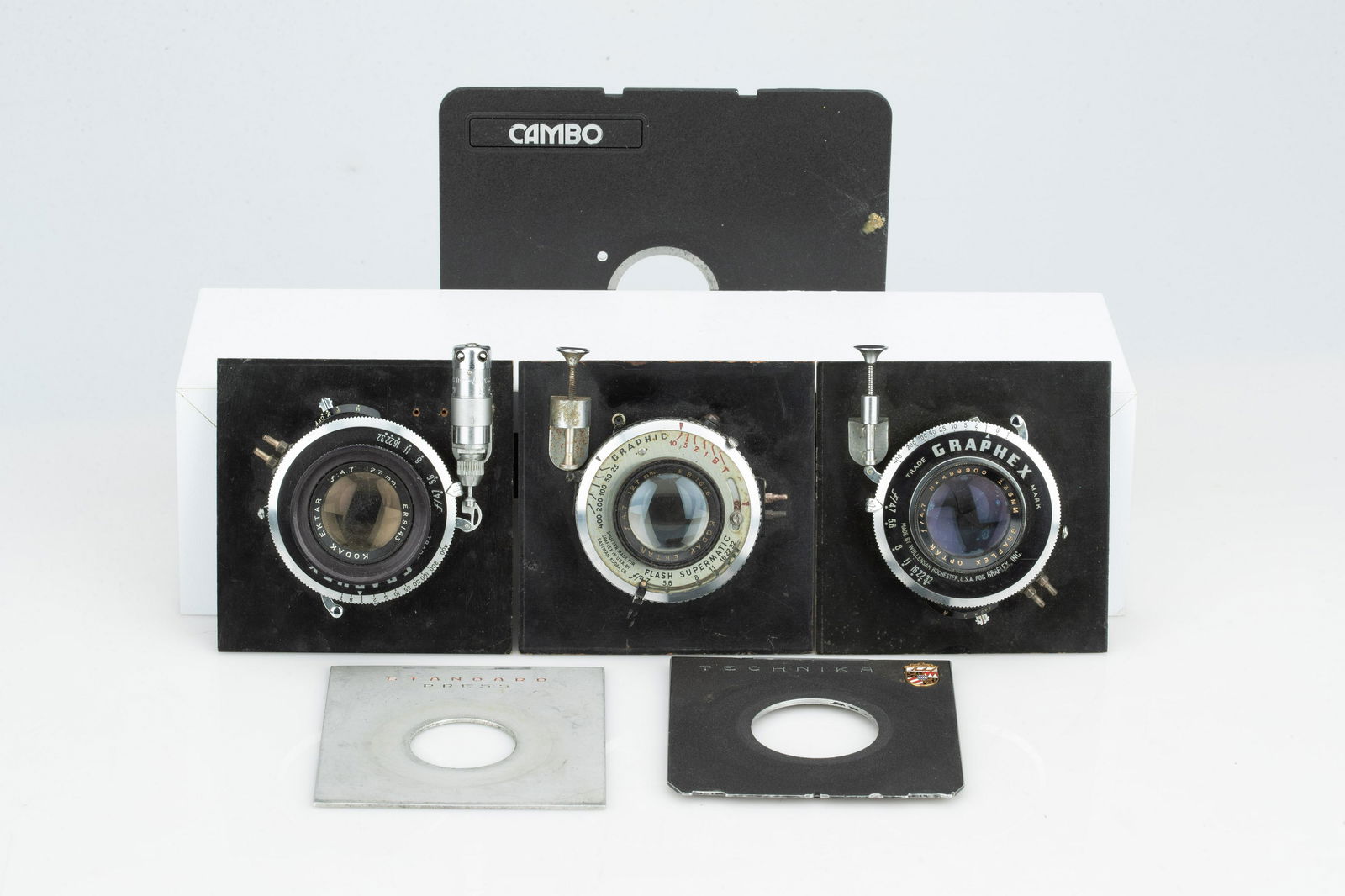 Three Large Format Lenses in Boards,: including a two Kodak 127mm f/4.7s, and a Graflex Optar 135mm f/4.7, all untested, with other lens boards, (Qty: 1)