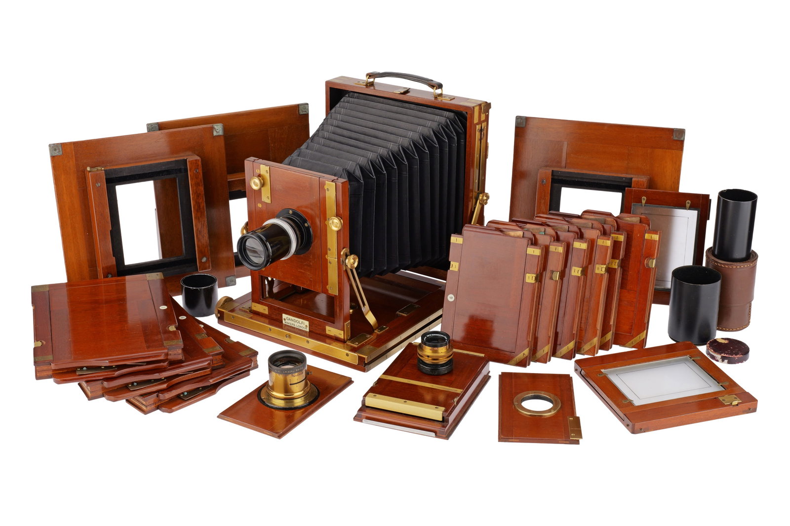 A Comprehensive Gandolfi Half-Plate Mahogany and Brass Camera Outfit,: of mahogany and brass construction, English, VG-E, the bellows appear VG, tilt and rise controls operate well, fitted with a half plate focusing screen, and a number of backs and films holders: 3off q