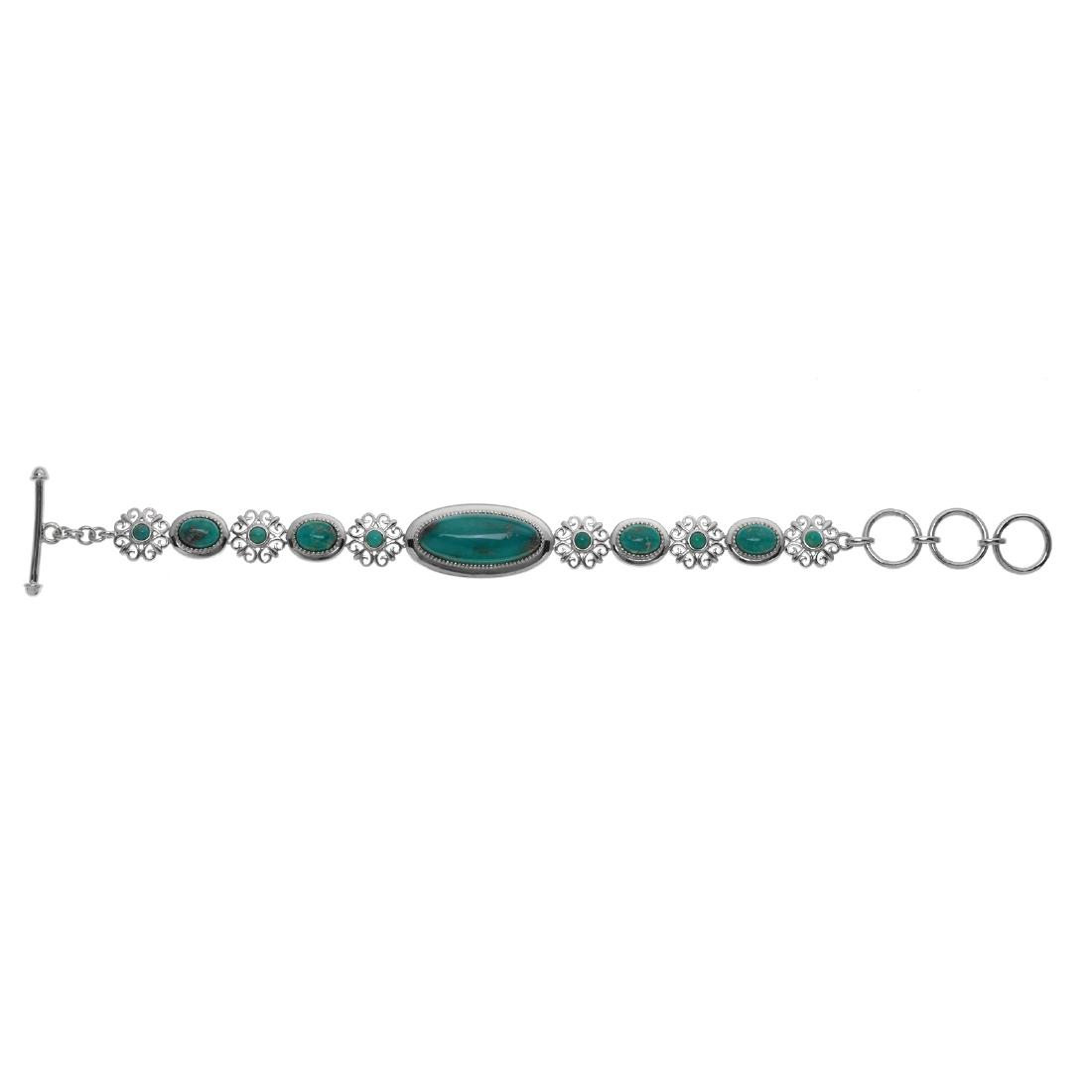 Sterling Silver Campo Frio Turquoise Toggle Bracelet: One large oval Genuine Blue Campo Frio Turquoise cabochon anchors the piece at the center. Round Campo Frio Turquoise cabochons in floral motif stations and oval stations alternate out from that cente