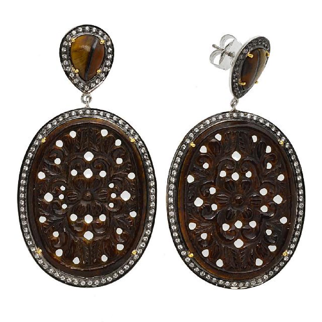 Silver Tiger's Eye & Topaz Carved Drop Earrings: • Genuine carved tiger's eye & white topaz • 1.88ct white topaz • Floral carved tiger's eye surrounded by white topaz • Comfortable butterfly clasp • Gleaming rhodium wit