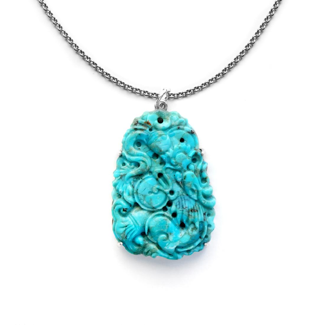 Sterling Silver Carved Turquoise Pendant: • Genuine carved turquoise • Dragon motif carved on the turquoise • Comfortable butterfly clasp • Gleaming rhodium over fine sterling silver • 18 inch silver chain