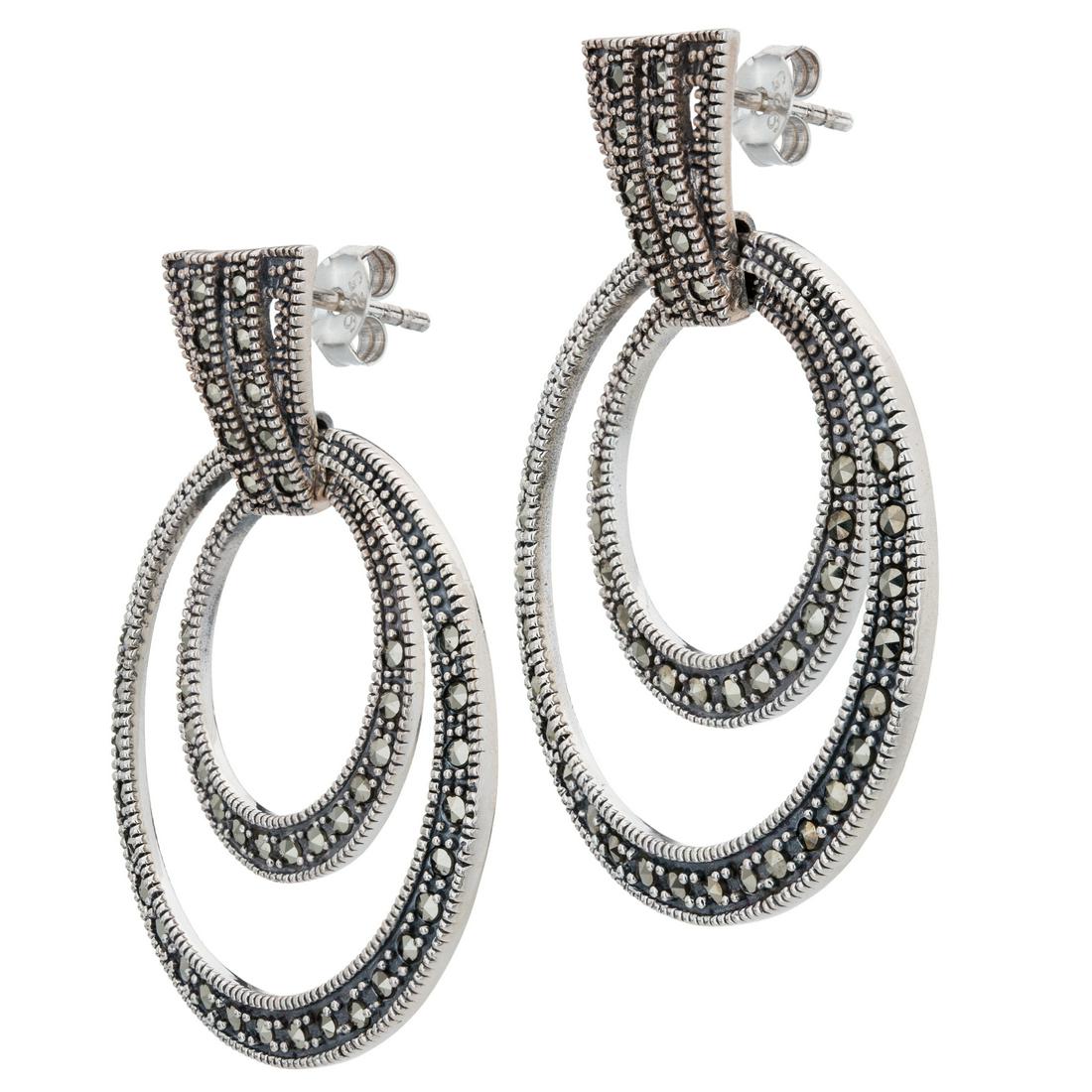 Sterling Silver Marcasite Orbital Hoop Earrings: Sport a dramatic look from Addison Lane’s Weekend Collection! Big, bold orbital hoops are gracefully styled in oxidized sterling silver and lavishly adorned with sparkling marcasite to create a 