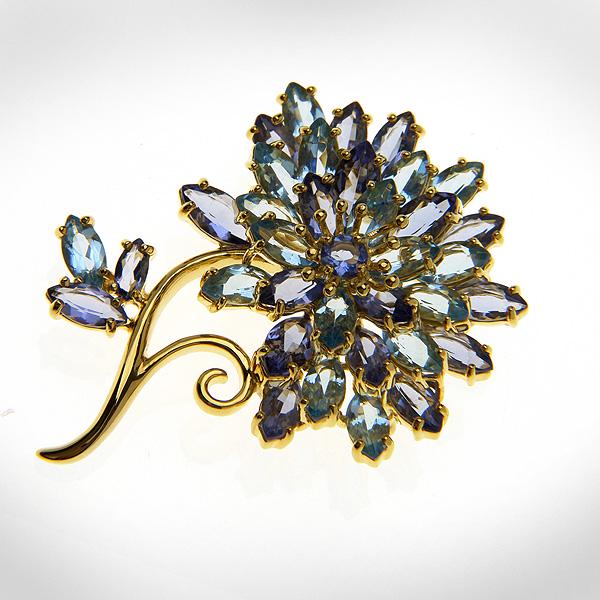 18k Gold over Sterling Silver Flower Pin: Sky blue topaz stones and vividly iris-blue tanzanites are combined in this dazzling pin design. Wear this pin for formal or not so formal engagements. Crafted in gleaming 18k vermeil this piece is su