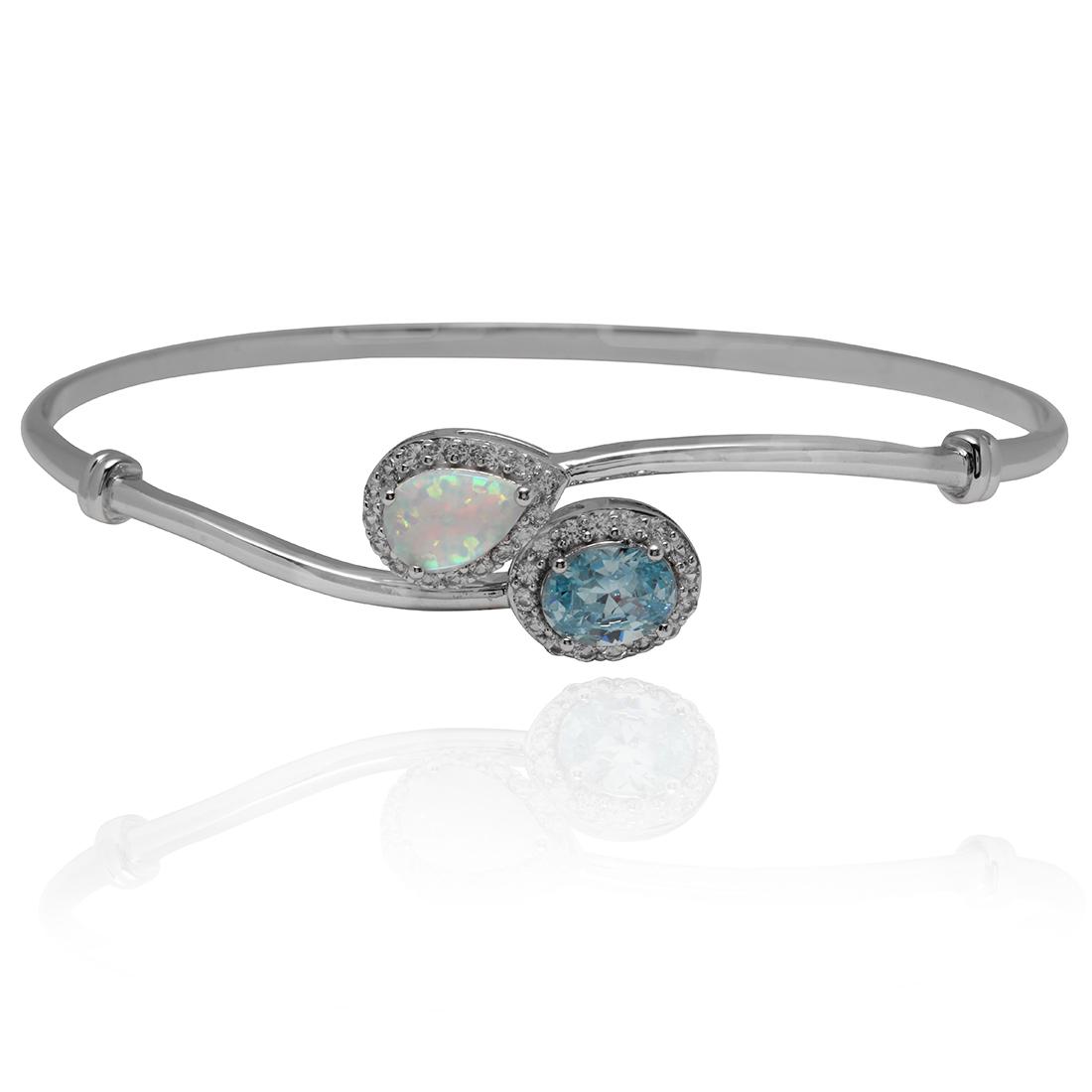 Blue Topaz and Created Opal S/S Bangle Bracelet: Blue Topaz and Created Opal Sterling Silver Bangle Bracelet • Metal: Sterling Silver• Stone: Blue Topaz,Created Opal• Total Weight: 8.8 grams• Finish: Rhodium• Length: 7 