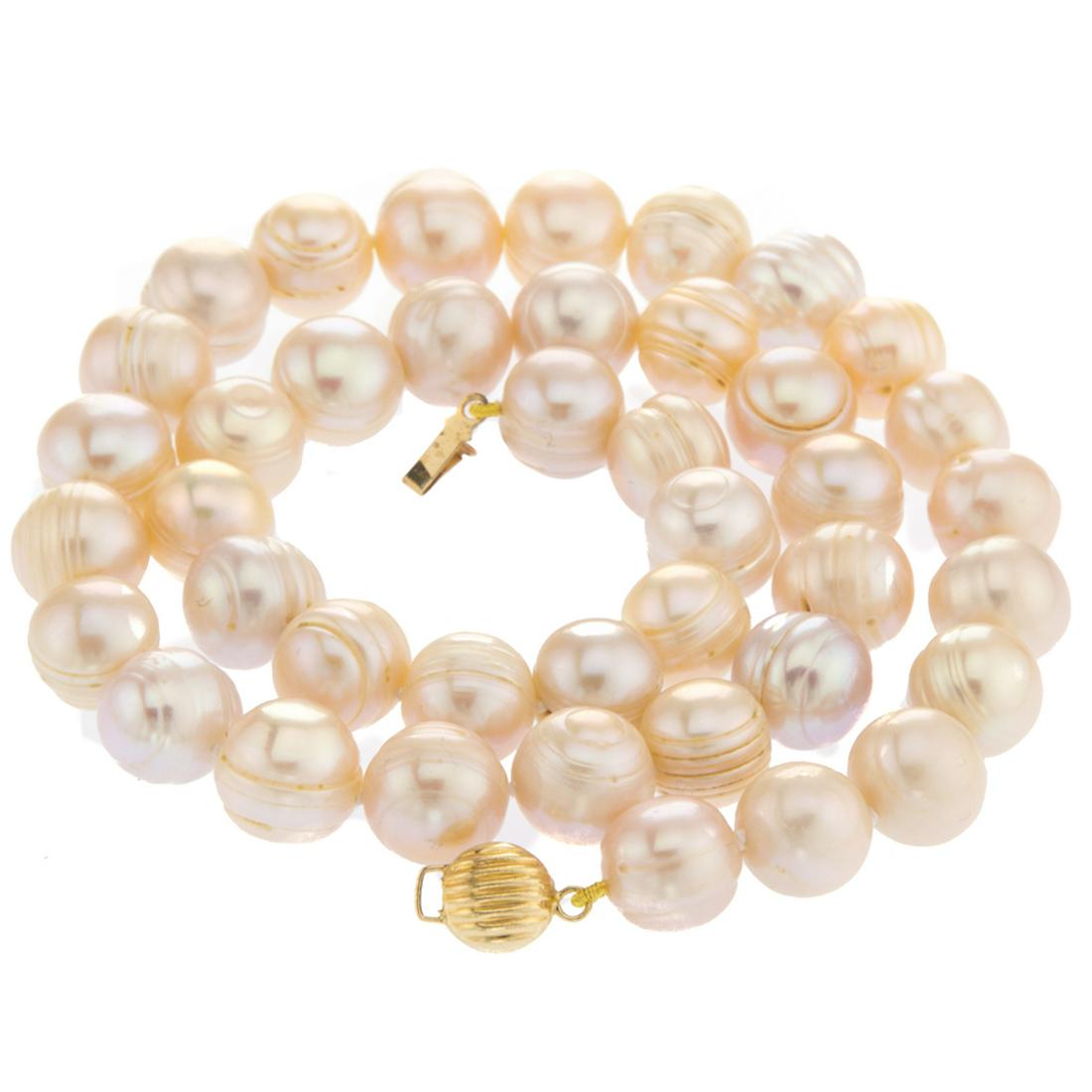 14K Gold Baroque Pearl Necklace: • Genuine pink freshwater baroque pearl• 9-11mm sizes pearls• 16 inch length• 14K yellow gold insert clasp