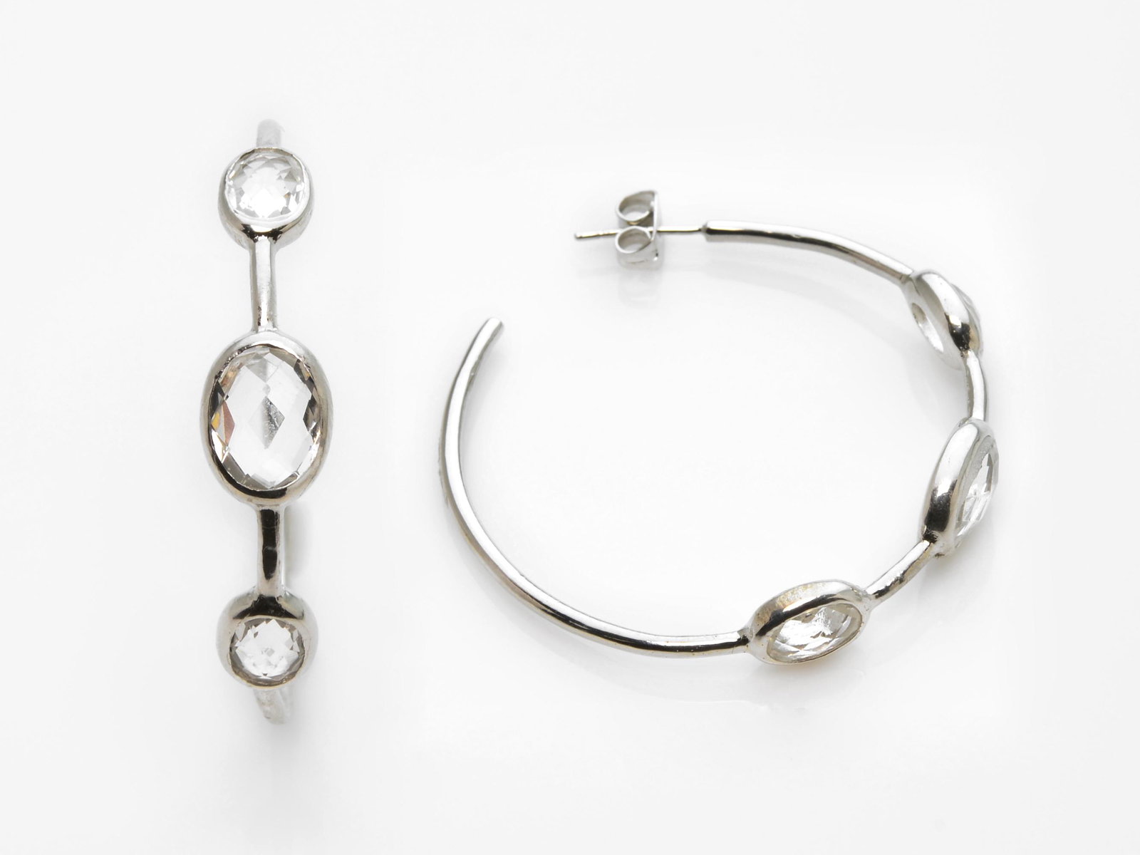 Silver Tone Cubic Zirconia Hoop Earrings: • Cubic Zirconia• 40mm• Butterfly backings for comfortable fit• Gleaming rhodium over brass