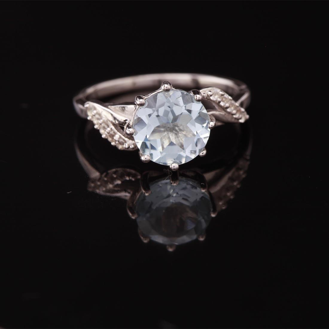 Sz 8 Sterling Sky Blue Topaz & Zircon Ring: Sz 8 Sterling Sky Blue Topaz & Zircon Ring • Metal: Sterling Silver • Stone: (1)8Mm-Sky Blue Topaz &White Zircon • Width: 9.1 Mm • Total Weight: 2.53 Grs • Finish: Rhodiu