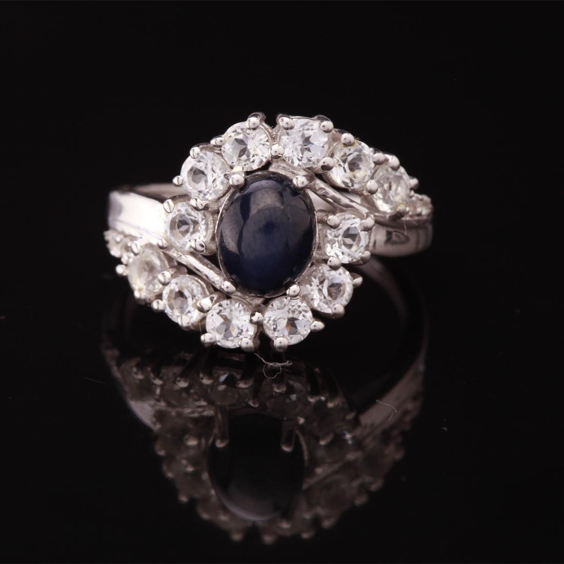 Size 10 Star Sapphire & Zircon Sterling Slv Ring: Size 10 Star Sapphire & Zircon Sterling Slv Ring • Metal: Sterling Silver • Stone: (1)8X6Mm-Star Blue Sapphire &White Zircon • Width: 14.6 Mm • Total Weight: 3.77 Grs • F