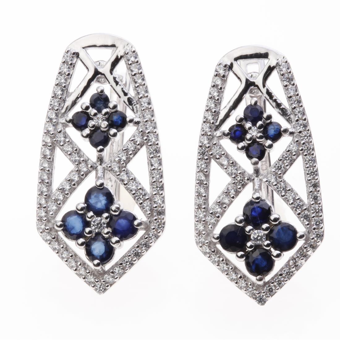 Sapphire & Zircon Interwine Silver Earrings: Sapphire & Zircon Interwine Silver Earrings .Metal: Sterling Silver .Stone: 3 Mm Rd Blue Sapphire&Zircon .Dimension: 26.6X13.3Mm .Total Weight: 7.4 Grams .Finish: Rhodium .Backing: French Clip
