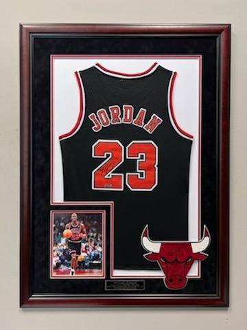 Michael Jordan Signed Away Jersey: Michael Jordan Black/Red Signed Away Jersey. This jersey has been professionally custom matted and framed and comes with a certificate of authenticity from Guaranteed Forensic Authenticators