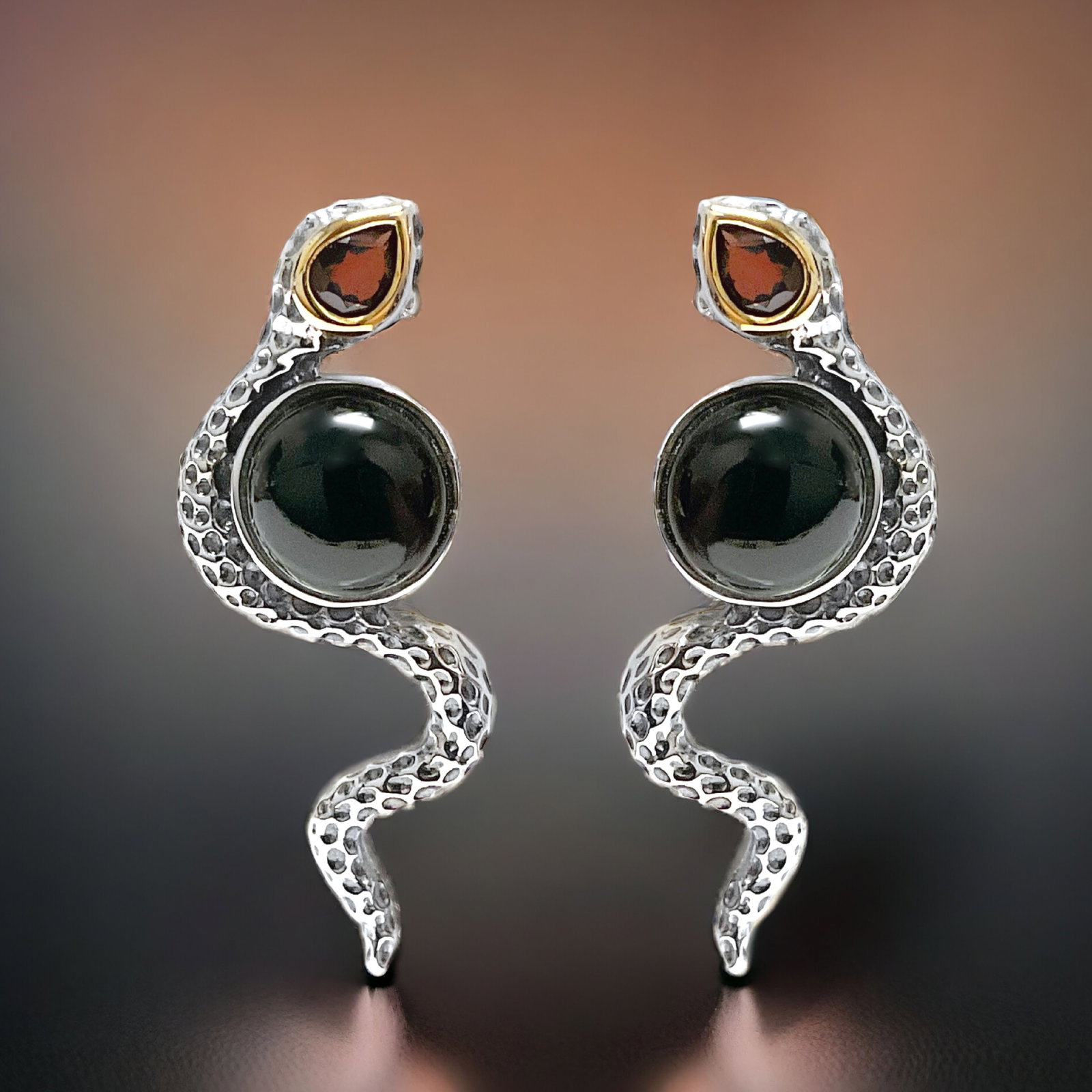 14K & Sterling Silver Onyx & Garnet Snake Earrings: Indulge in the allure of these 14K Gold and Sterling Silver Snake Earrings, adorned with captivating Black Onyx and Garnet gemstones. The sinuous design of the serpents adds a touch of mystique to you