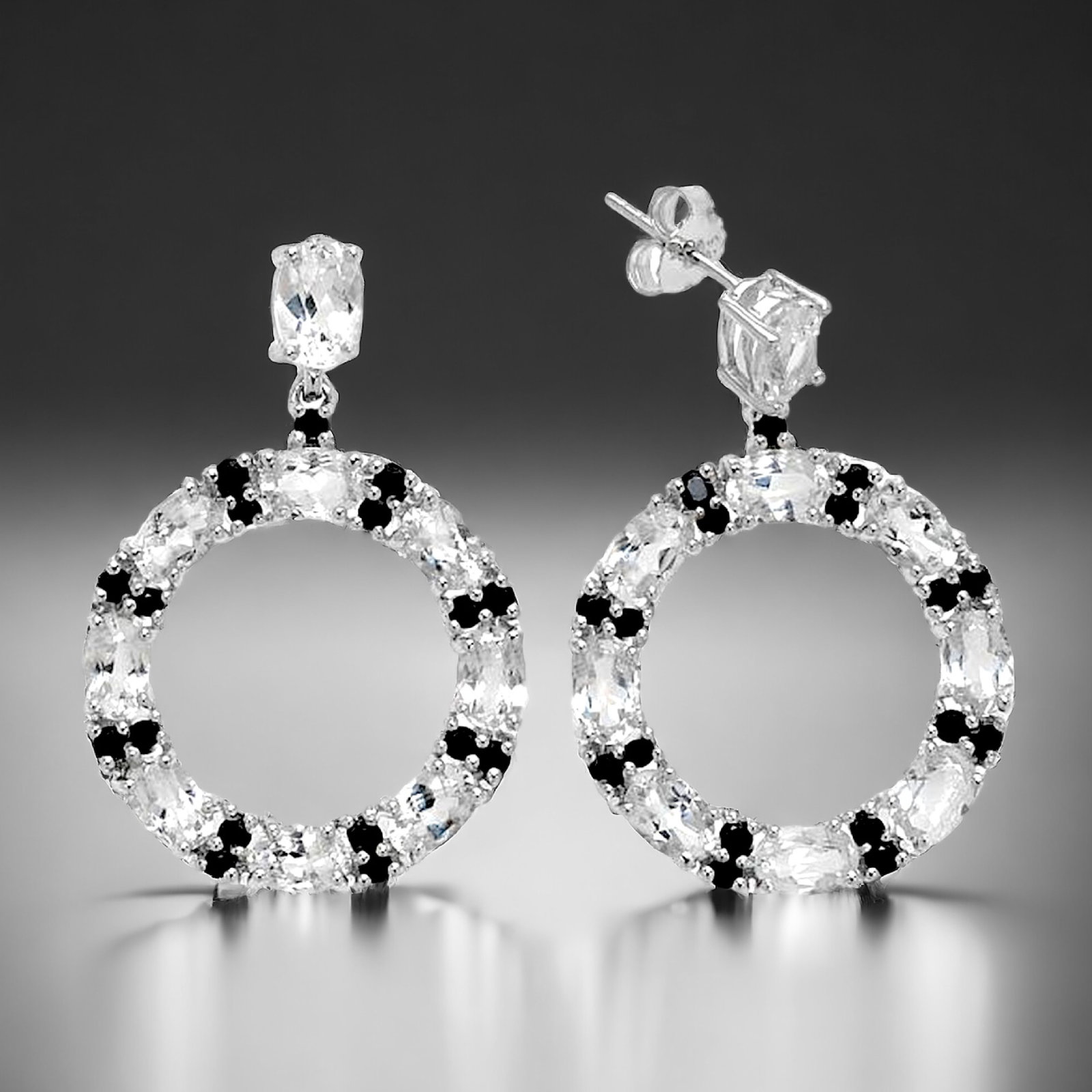 10.8ct White Topaz & Black Spinel Sterling Silver Hoop Earrings: Product Details Item: Earrings Metal: Sterling Silver Gemstone: 9.90ct White Topaz & .91ct Black Spinel Approximate Measurements: 38 mm X 26 mm Ring Size: Not Applicable Chain Length: Not Appl