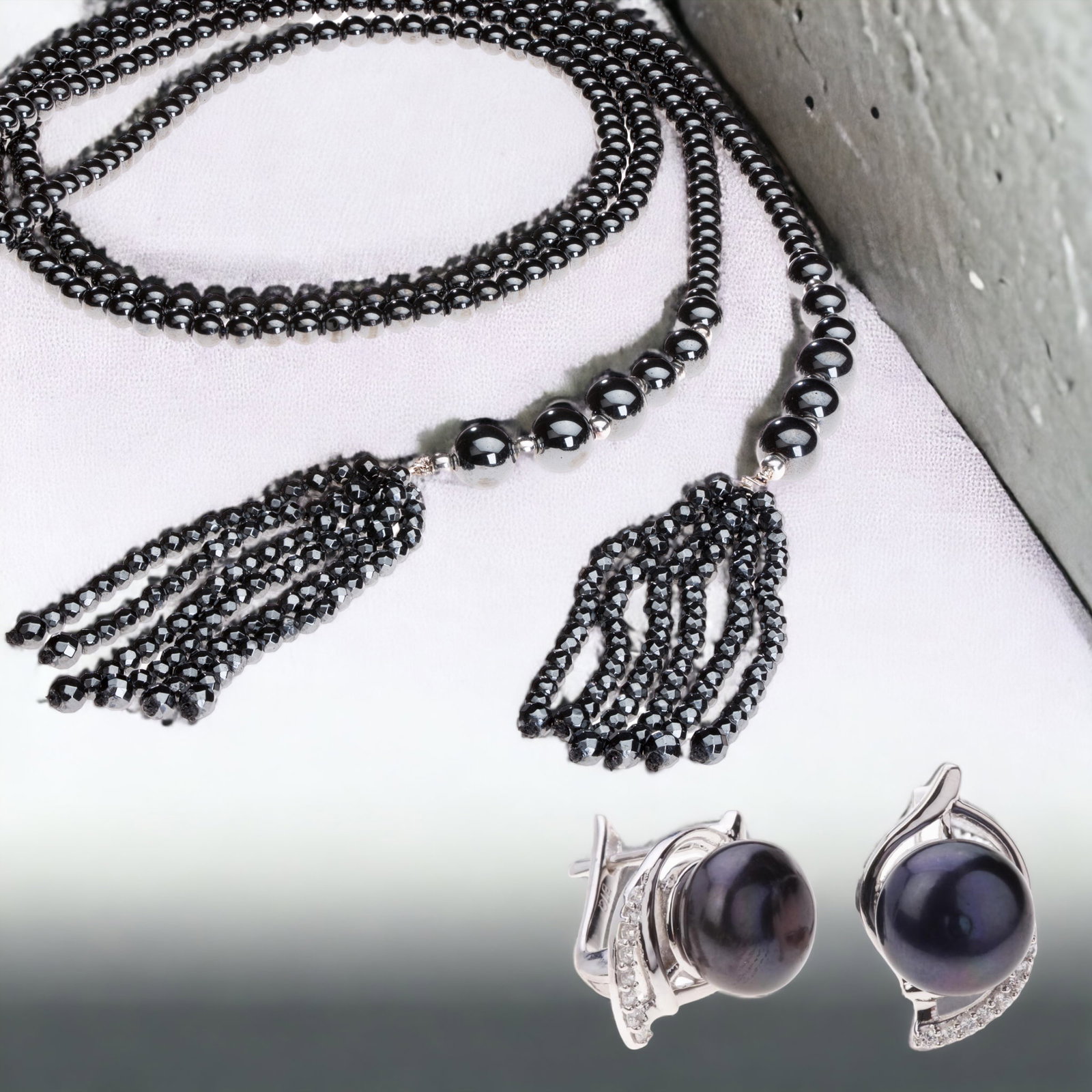 Elegant Hematite Tassel Necklace & Pearl Earrings: Adorn yourself with this exquisite collection featuring a sterling silver tassel necklace adorned with shimmering hematite stones, boasting a generous length of 45 inches. Complementing this, a pair o