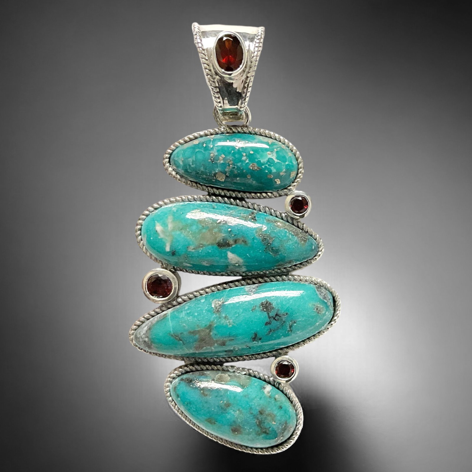 One of a kind Campo Frio Turquoise Pendant combined with Garnet and crafted in Sterling Silver: Product Details Item: Pendant Metal: Sterling Silver Gemstone: Campo Frio Turquoise & Garnet (Mozambique) Approximate Measurements: 70.1 mm X 34.2 mm Ring Size: Not Applicable Chain Length: N