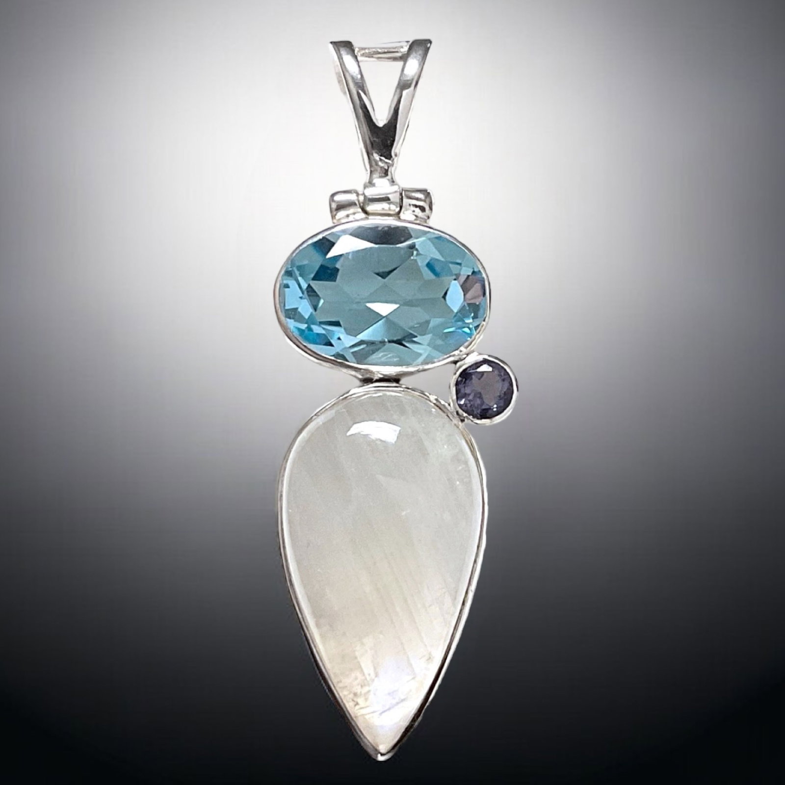 Moonstone , Blue Topaz and Iolite Sterling Silver Pendant: Product Details Item: Pendant Metal: Sterling Silver Gemstone: Blue Topaz, Moonstone, & Iolite Approximate Measurements: 49.8 mm X 16.2 mm br> NO RETURNS NO EXCHANGE ALL SALES ARE FINAL