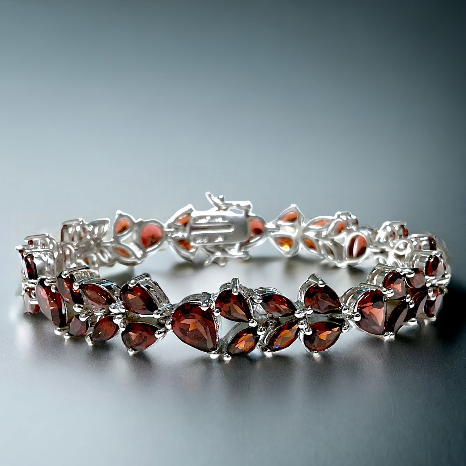 Noble Sterling Silver Bracelet with crafted with semi-precious Garnet Gemstones: Product Details Item: Bracelet Metal: Sterling Silver Gemstone: Garnet Approximate Measurements: 7.5" X 11 mm Ring Size: Not Applicable Chain Length: Not Applicable Chain Metal: Not