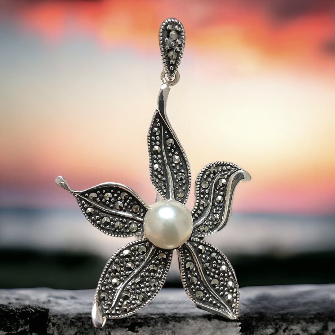 Enchanting Pearl & Marcasite Star Pendant crafted in Sterling Silver: Product Details Item: Pendant Metal: Sterling Silver Gemstone: Pearl & Marcasite Approximate Measurements: 47.3 mm X 28.7 mm Ring Size: Not Applicable Chain Length: Not Applicable Chain