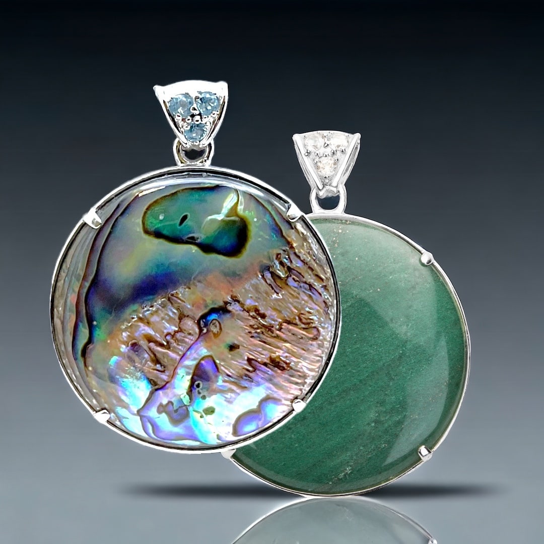 Elegant Reversible Sterling Silver Pendant with Green Adventurine on one side and Abalone on the: 40 mm Round Centerstones: Abalone & Green Adventurine Product Details Item: Pendant Metal: Sterling Silver Gemstone: Adventurine, Abalone, Swiss Blue Topaz, & White Topaz Approximate Measurements: 53.
