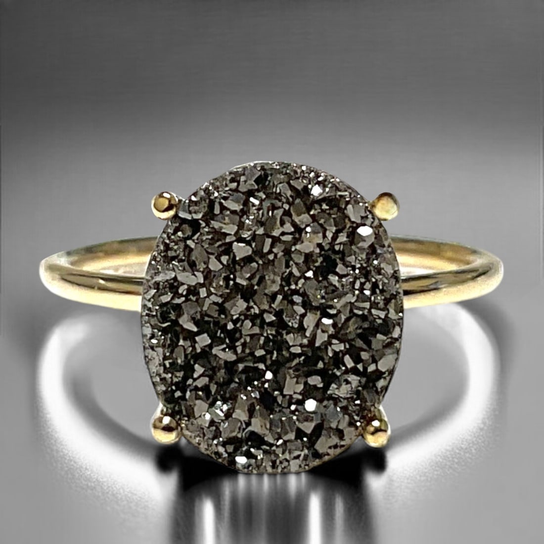 14K Gold Ring with Shimmering Silver Drusy Center: Product Details Item: Ring Metal: 14K Gold Gemstone: Grey Drusy Approximate Measurements: W-11.9 mm Ring Size: 7 Chain Length: Not Applicable Chain Metal: Not Applicable NO RET