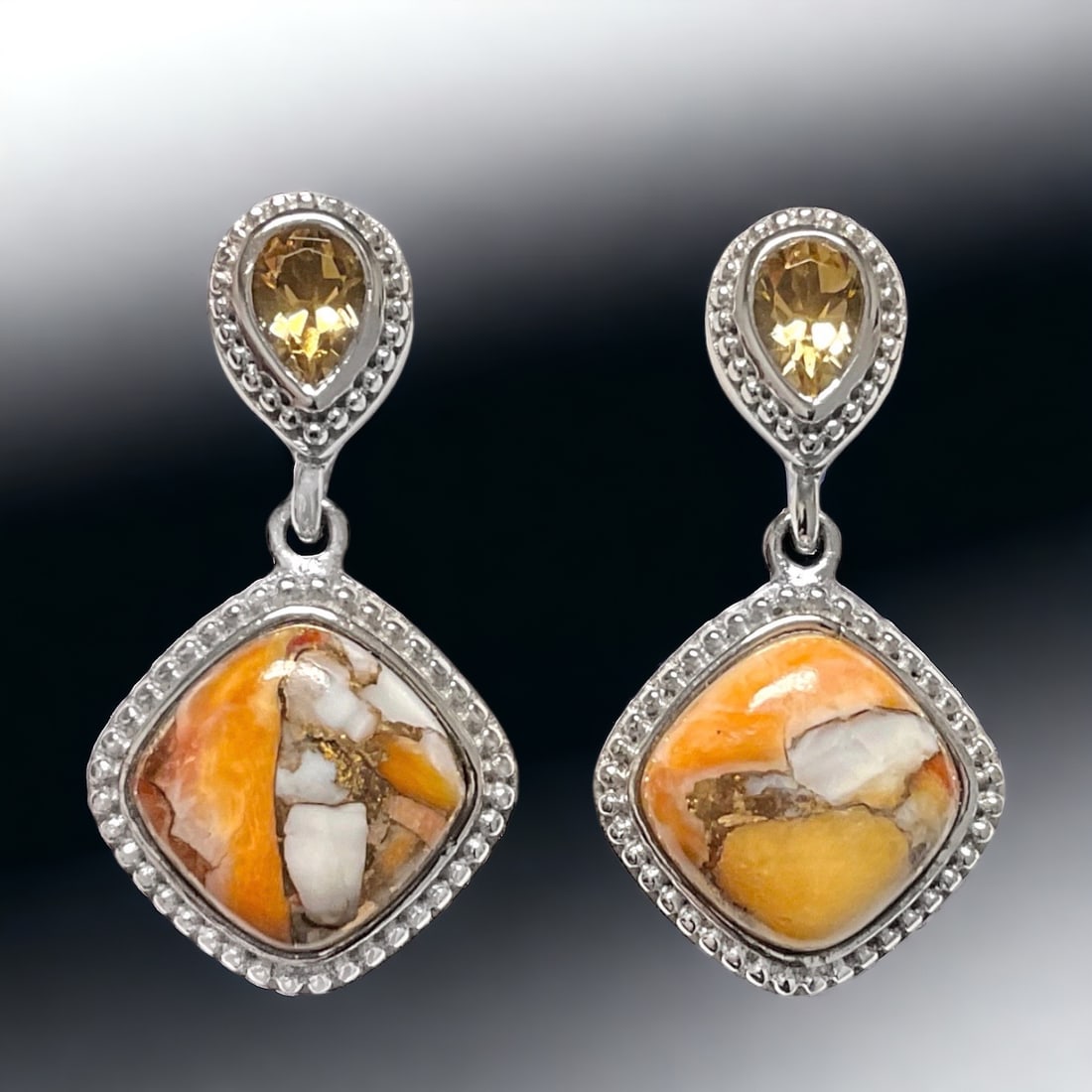 Spiney Oyster Sterling Silver Earrings with Citrine Accents and Filigree Detailing: Stabilized Spiny Oyster: Two cushion shaped 10 mm cabochons Citrine: Two pear cut 6 mm X 4 mm Product Details Item: Earrings Metal: Sterling Silver Gemstone: Spiny Oyster & Citrine Approximate Measur