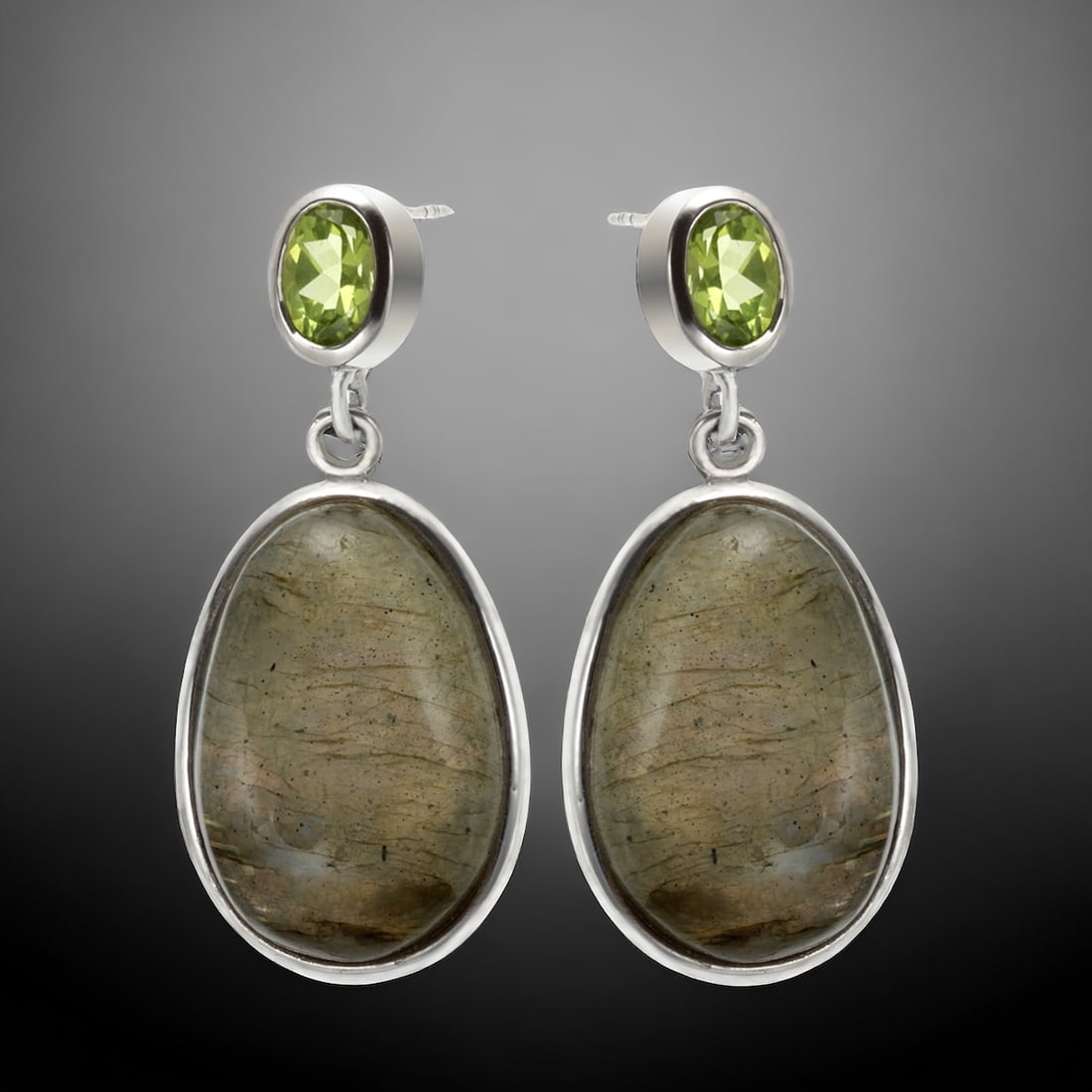 Oval Labradorite & Peridot Sterling Silver Drop Earring: Labradorite: Two oval 22 mm X 15 mm cabochons Peridot: Two oval cut 7 mm X 5 mm Product Details Item: Earrings Metal: Sterling Silver Gemstone: Labradorite & Peridot Approximate Measurements: 38.4 mm