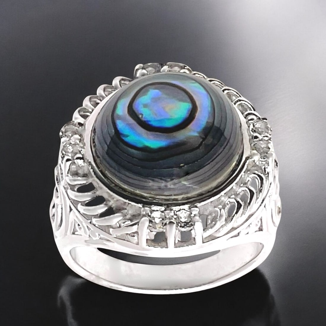 Oceaniac Abalone Sterling Silver Ring adorned with White Topaz - Size 7: Product Details Item: Ring Metal: Sterling Silver Gemstone: Abalone & White Topaz Approximate Measurements: Width: 18.9 mm Ring Size: 7 Chain Length: Not Applicable Chain Metal: Not Ap