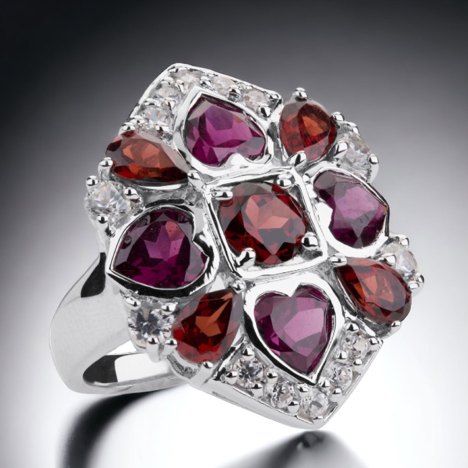 7.68 cttw Multi Garnet & Topaz Cocktail Ring - Size 6: 3.04 cttw Mozambique Garnet: One round modified-brilliant cut 6 mm and four pear cut 6 mm X 4 mm 3.56 cttw Rhodolite Garnet: Four heart cut 6 mm X 6 mm 1.09 cttw White Topaz: 14 round modified-brillia