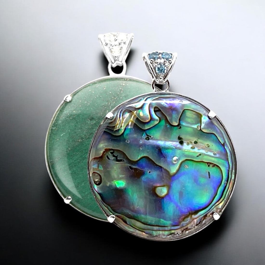 Elegant Reversible Sterling Silver Pendant with Green Adventurine and Abalone: 40 mm Round Centerstones: Abalone & Green Adventurine Product Details Item: Pendant Metal: Sterling Silver Gemstone: Adventurine, Abalone, Swiss Blue Topaz, &White Topaz Approximate Measurements: 53.5