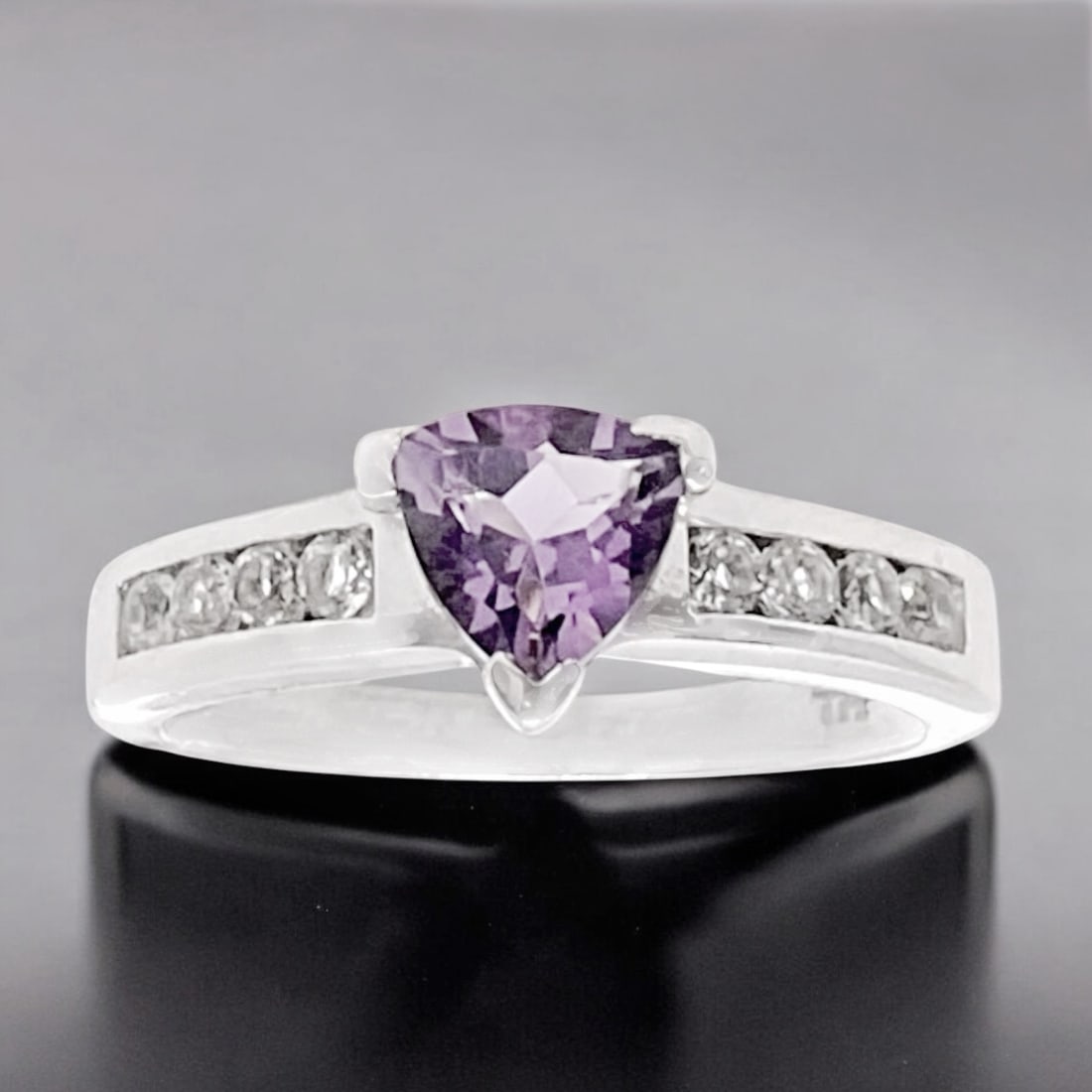 Trillion Amethyst centerstone on a Sterling Silver Ring adorned with sparkling White Topaz - Size 7: Product Details Item: Ring Metal: Sterling Silver Gemstone: Amethsyt & White Topaz Approximate Measurements: Width: 6.7mm Ring Size: 7 Chain Length: Not Applicable Chain Metal: Not App