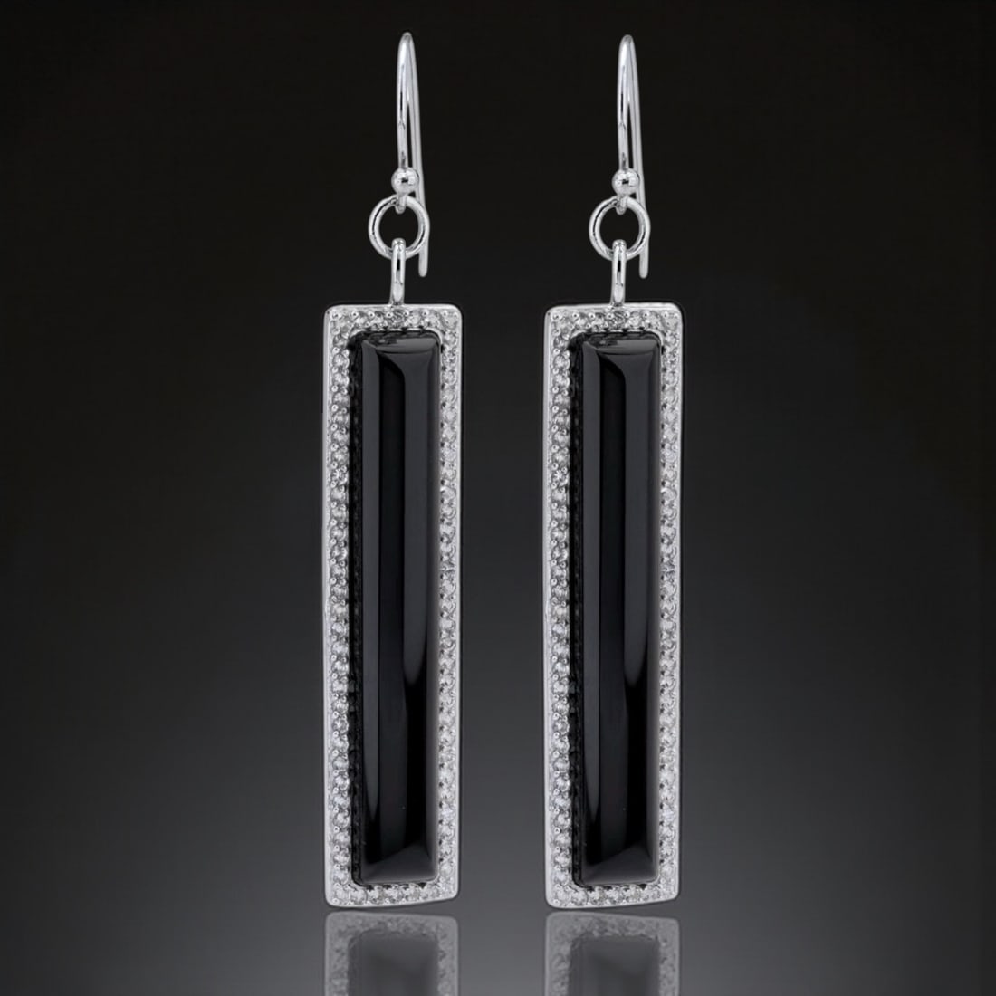Elongated Black Agate adorned with White Topaz Silver Earrings: Black Agate: 2 Gemstones each: 42 mm X 7 mm White Topaz: (144) 1 mm round Product Details Item: Earrings Metal: Sterling Silver Gemstone: Black Agate & White Topaz Approximate Measurements: 65.5 mm X