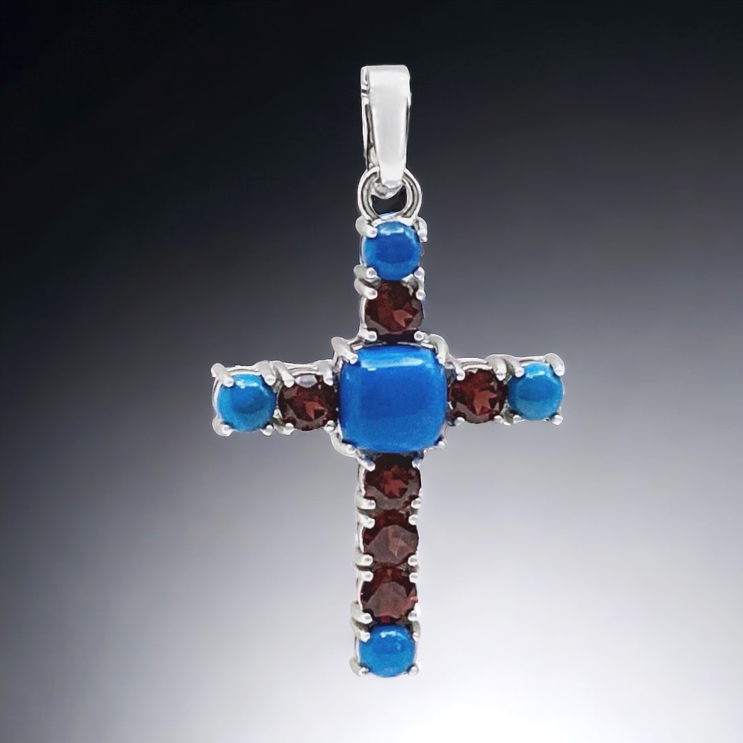 Spiritual Blue Ceruleite & Garnet Sterling Silver Cross Pendant: Stabilized Ceruleite: One cushion shaped 9.5 mm cabochon and four round 5 mm cabochons Garnet: Six round modified-brilliant cut 5 mm Product Details Item: Pendant Metal: Sterling Silver Gemstone: Ceru