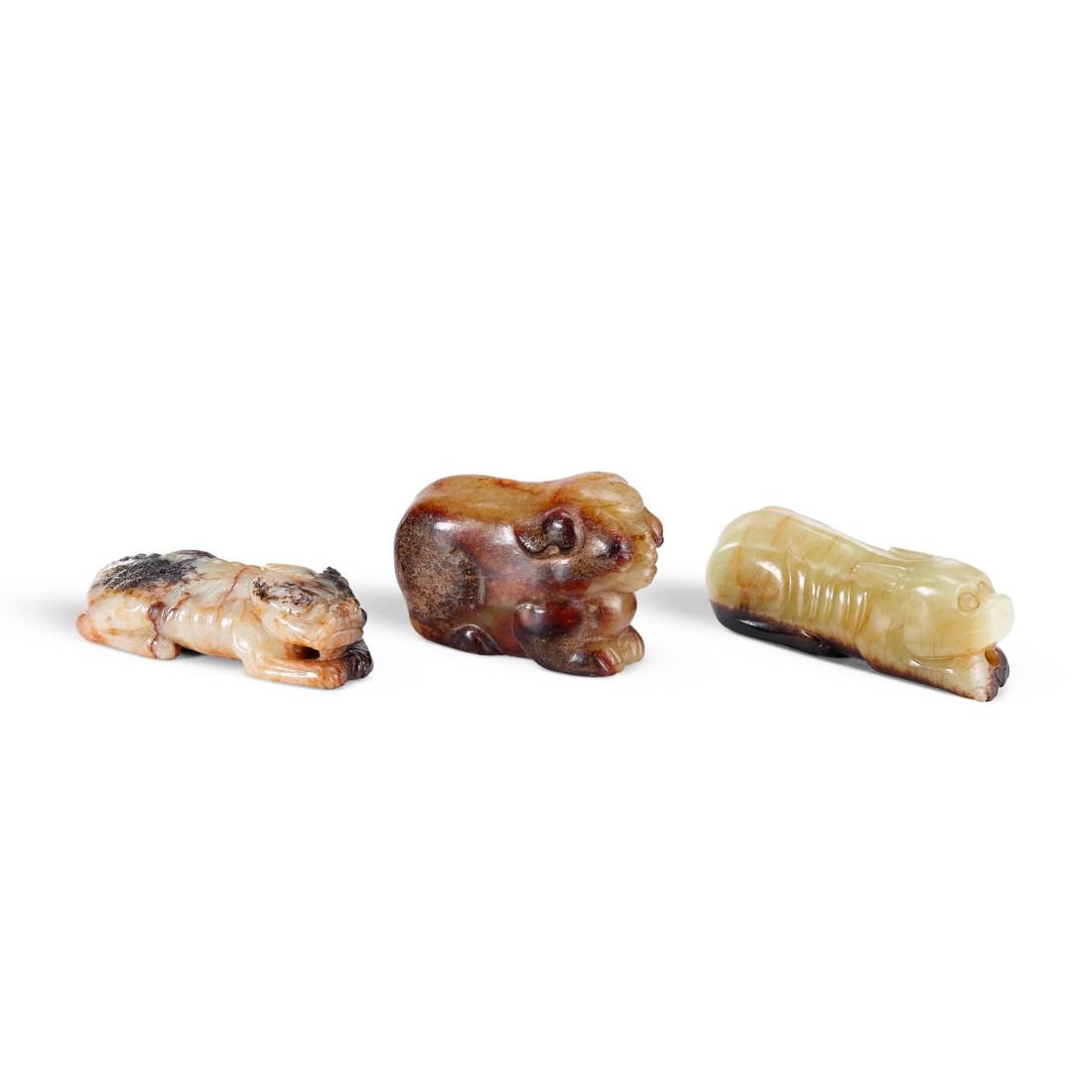 A GROUP OF THREE MOTTLED JADE ‘ANIMAL’ CARVINGS