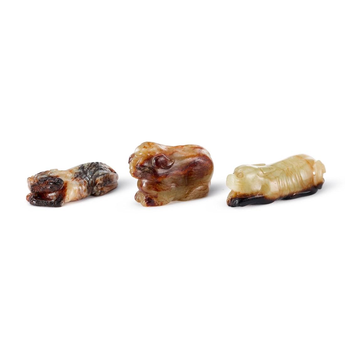 A GROUP OF THREE MOTTLED JADE ‘ANIMAL’ CARVINGS