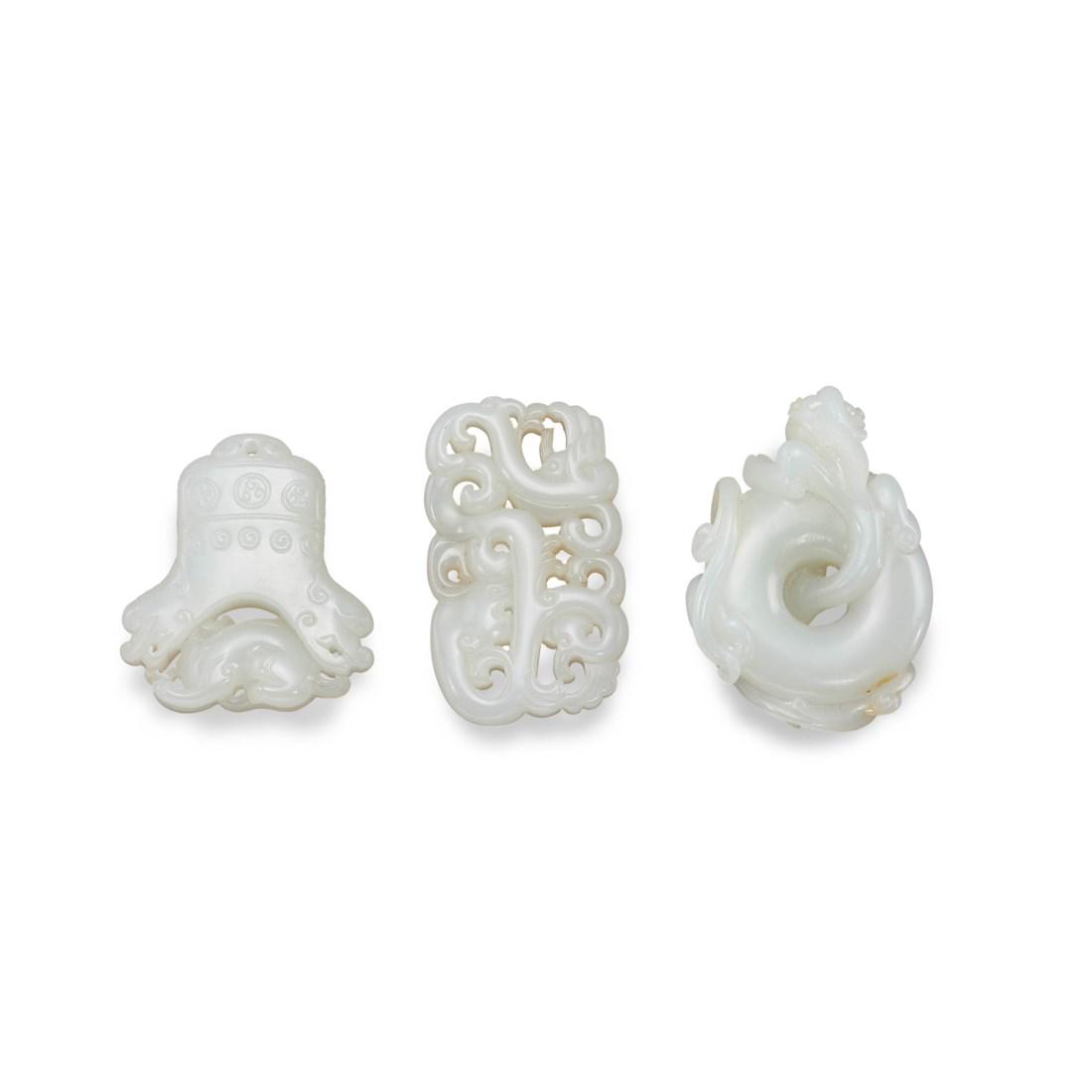 THREE CARVED WHITE JADE OPENWORK ‘DRAGON’ PENDANTS