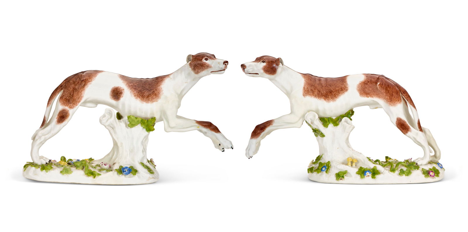 A PAIR OF MEISSEN PORCELAIN MODELS OF GREYHOUNDS THE PORCELAIN MID-18TH CENTURY, THE DECORATION OF: A PAIR OF MEISSEN PORCELAIN MODELS OF GREYHOUNDS THE PORCELAIN MID-18TH CENTURY, THE DECORATION OF LATER DATE, BLUE CROSSED SWORDS MARKS TO THE BACK OF EACH BASE, MODELED BY J.J. KÄNDLER 