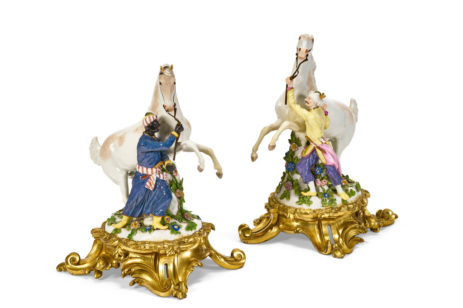 A PAIR OF ORMOLU-MOUNTED MEISSEN PORCELAIN FIGURE GROUPS OF HORSES AND GROOMS THE PORCELAIN CIRCA: A PAIR OF ORMOLU-MOUNTED MEISSEN PORCELAIN FIGURE GROUPS OF HORSES AND GROOMS THE PORCELAIN CIRCA 1750, BLUE CROSSED SWORDS MARKS, THE MODEL ATTRIBUTED TO J.J. KÄNDLER, THE MOUNTS OF LATER DATE 