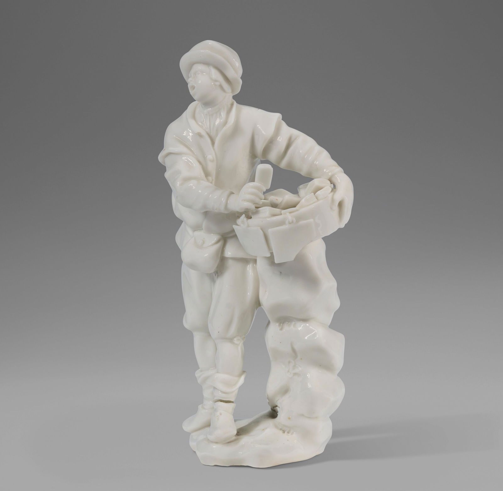 A CAPODIMONTE PORCELAIN WHITE FIGURE OF A BOOK AND PRINT SELLER CIRCA 1750, IMPRESSED FLEUR-DE-LYS: A CAPODIMONTE PORCELAIN WHITE FIGURE OF A BOOK AND PRINT SELLER CIRCA 1750, IMPRESSED FLEUR-DE-LYS MARK, MODELED BY G. GRICCI Details Standing in contraposto against stacked rocks supporting his baske