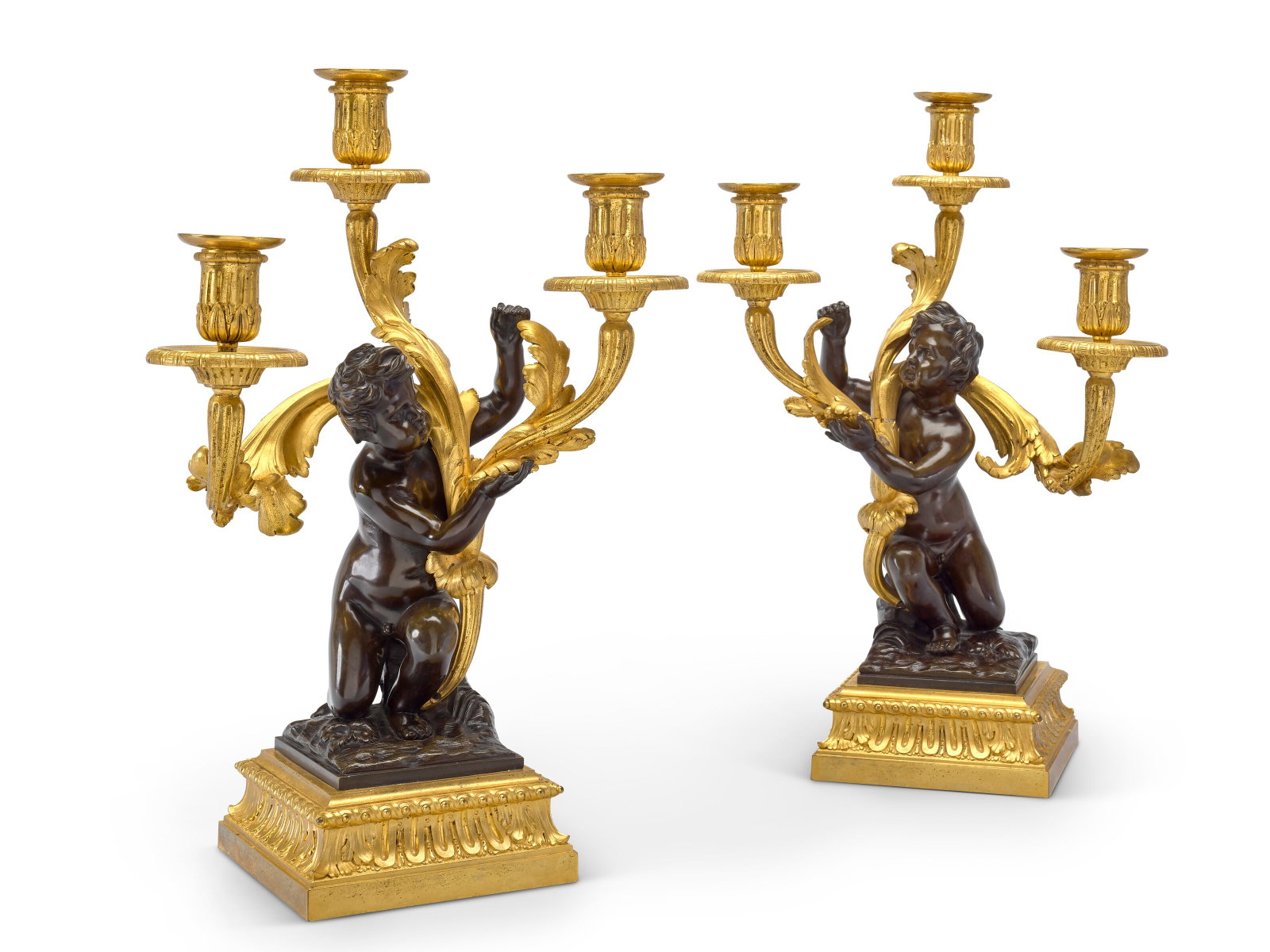 PAIRE DE CANDÉLABRES AUX PUTTI D’ÉPOQUE TRANSITION: Details PAIRE DE CANDÉLABRES AUX PUTTI D’ÉPOQUE TRANSITION VERS 1760 En bronze ciselé, doré et patiné, à trois bras de lumière en feuilles d’acanthe