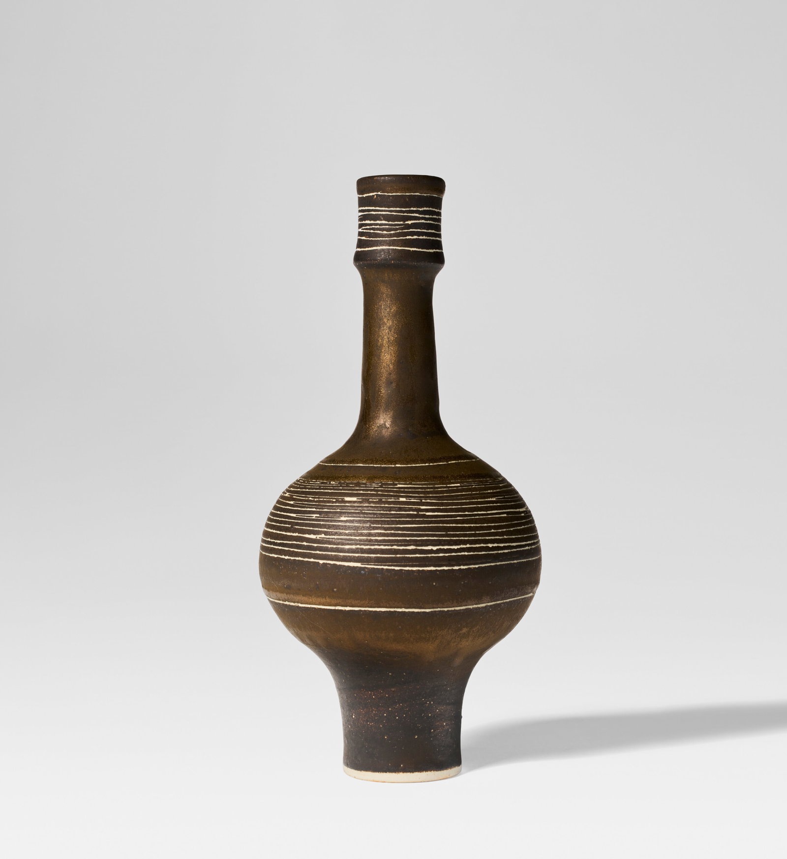 LUCIE RIE (1902-1995) Bottle, circa 1988: Details LUCIE RIE (1902-1995) Bottle, circa 1988 porcelain with golden manganese glaze and sgraffito 9 ¼ in. (23 cm) high, 4 3⁄8 in. (11 cm) diameter impressed with artist's seal