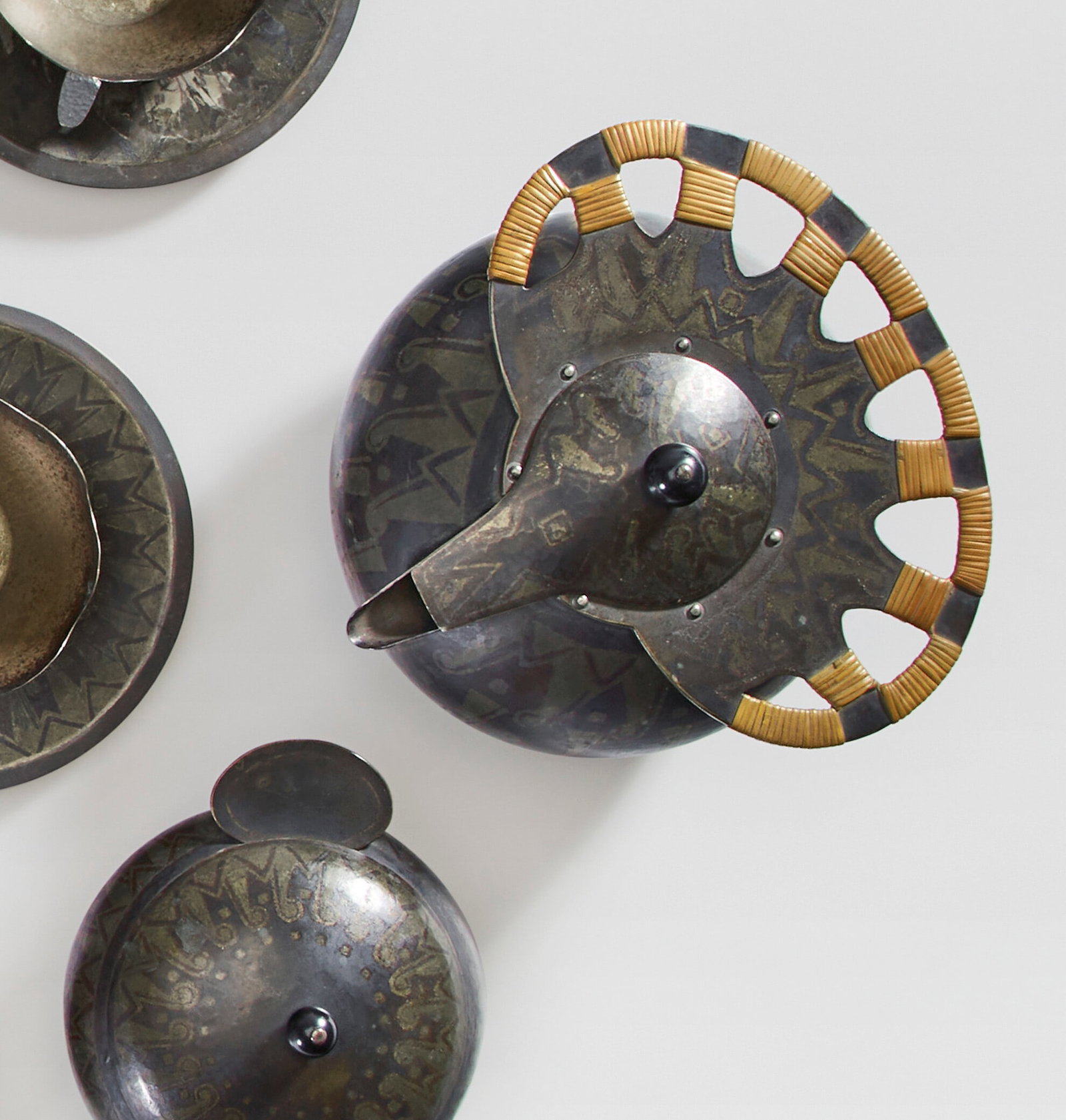 JEAN DUNAND (1877-1942) Tea Service, circa 1912: Details JEAN DUNAND (1877-1942) Tea Service, circa 1912 patinated and silver-inlaid maillechort, cane comprising: eight cups, eight saucers, a milk pot, a sugar bowl, a teapot and a teapot warmer teap