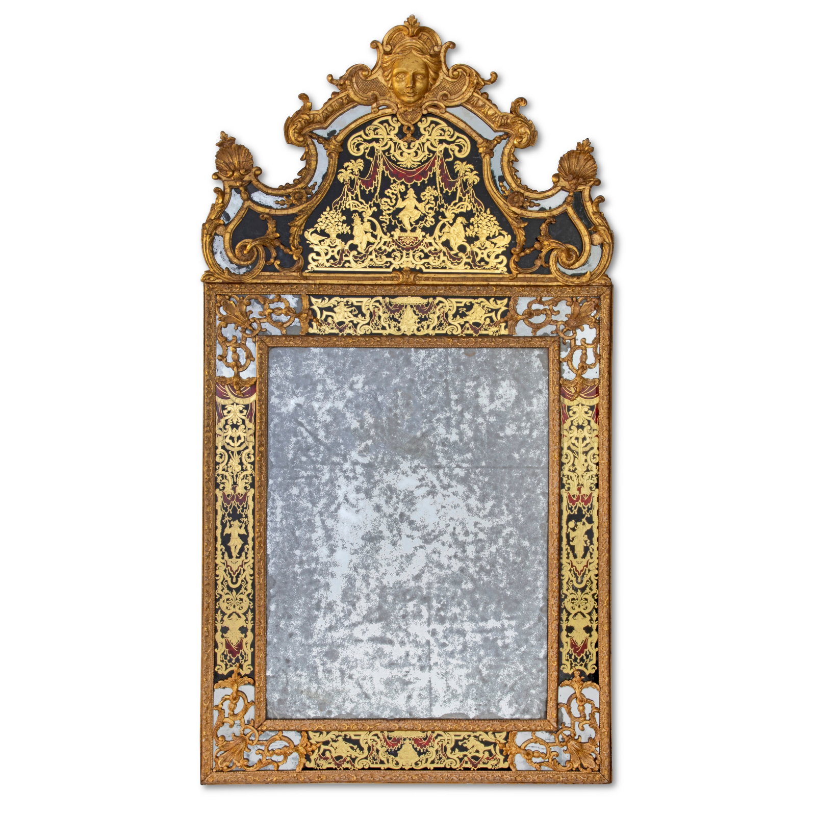 A LOUIS XIV GILTWOOD AND VERRE EGLOMISE MIRROR FIRST QUARTER 18TH CENTURY: Details A LOUIS XIV GILTWOOD AND VERRE EGLOMISE MIRROR FIRST QUARTER 18TH CENTURY The moulded frame carved with acanthus scrolls, strapwork and floral motifs, the cresting surmounted by a mask of Apol