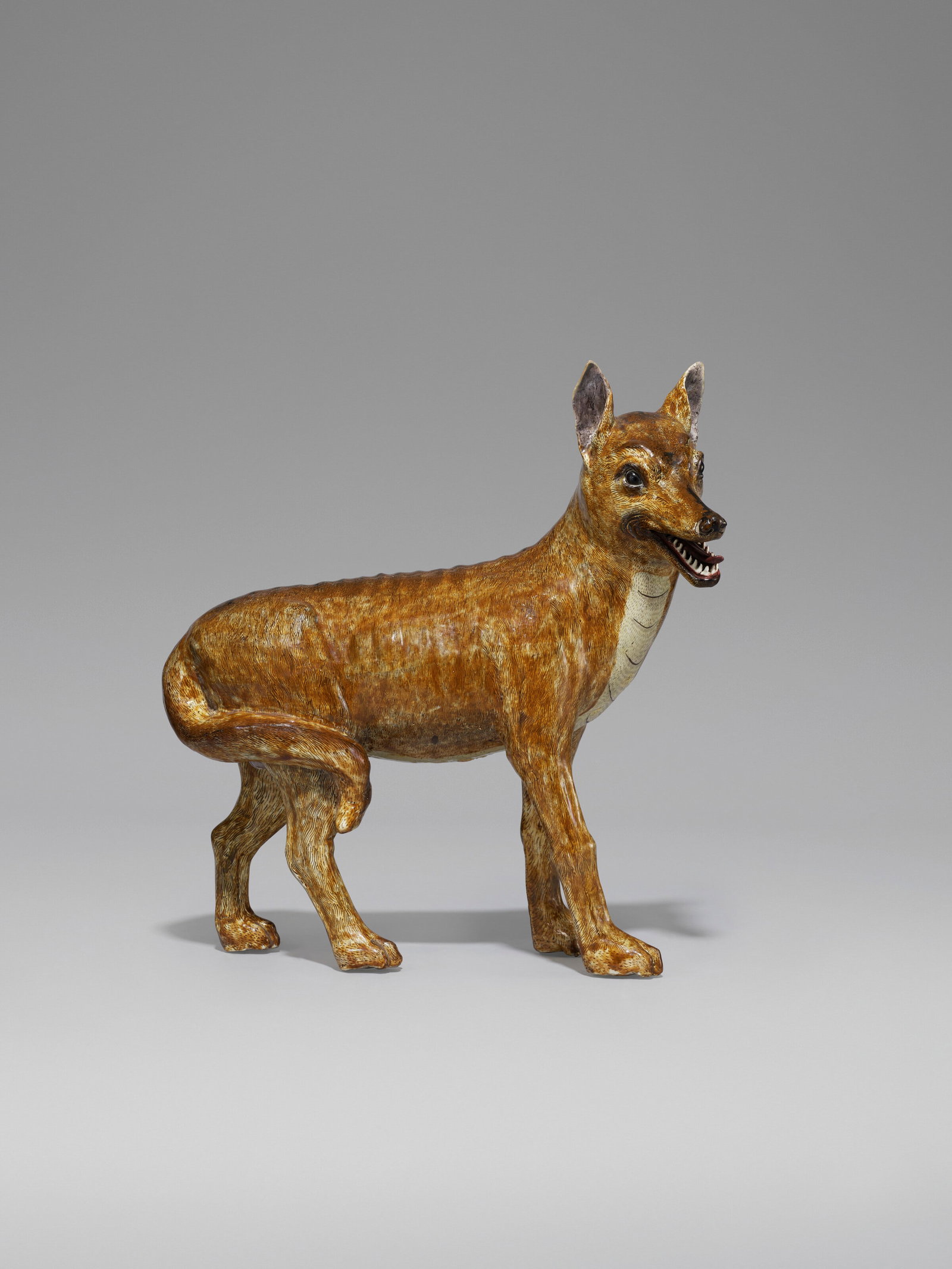 A LARGE CHINESE EXPORT PORCELAIN MODEL OF A WILD DOG (CHINESE DHOLE) 18TH CENTURY: Details A LARGE CHINESE EXPORT PORCELAIN MODEL OF A WILD DOG (CHINESE DHOLE) 18TH CENTURY The large canine standing with an alert expression, its ears pricked up and its mouth open to reveal pointed t