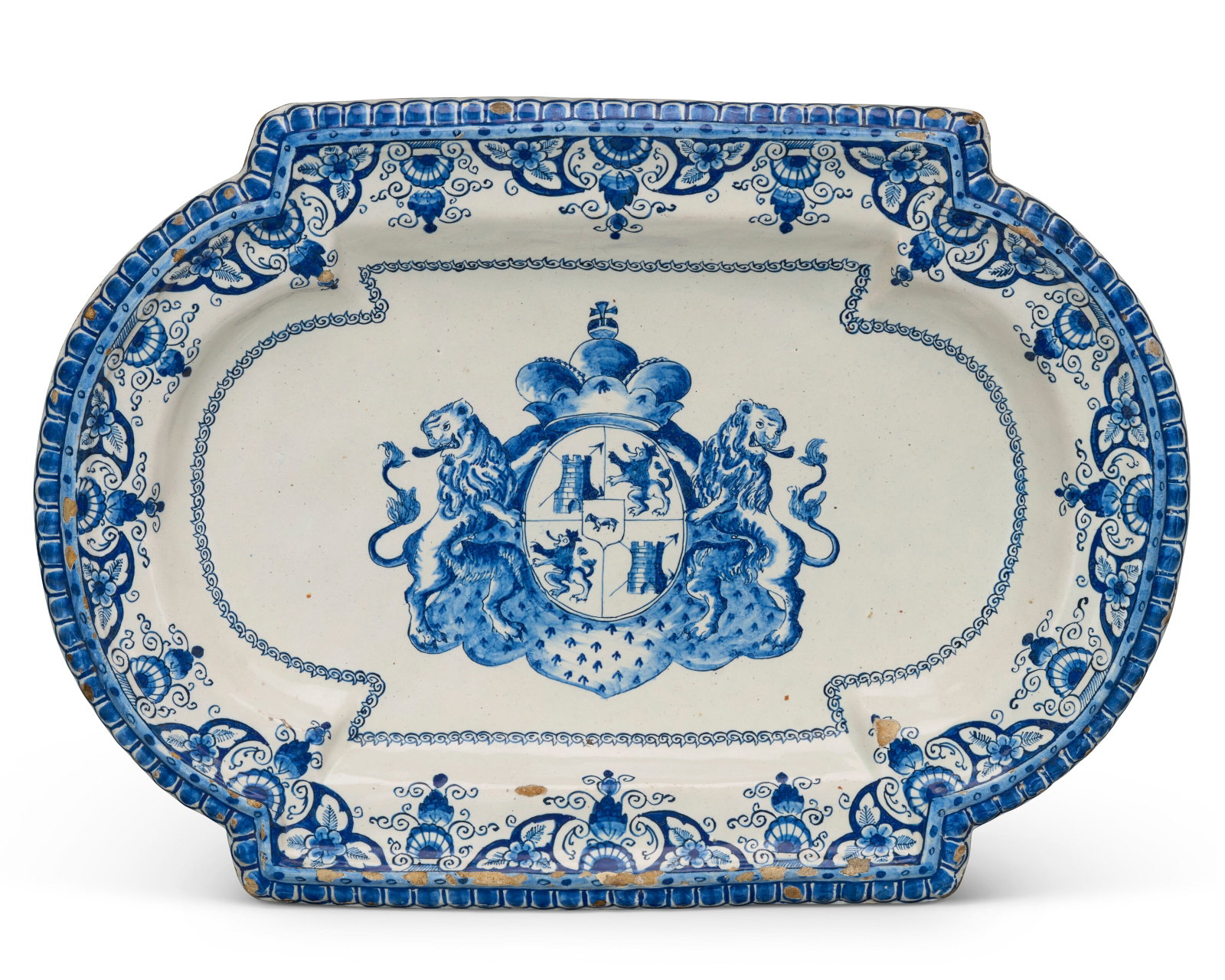A DUTCH DELFT BLUE AND WHITE SPANISH ARMORIAL SHAPED PLATTER CIRCA 1691-1700, BLUE LVE MONOGRAM MARK: Details In the Baroque style, after a silver example, the heavy body of arched rectangular form, painted with an elaborate crowned ermine-clad 'Spanish' coat-of-arms with the arms Castile quartered wi