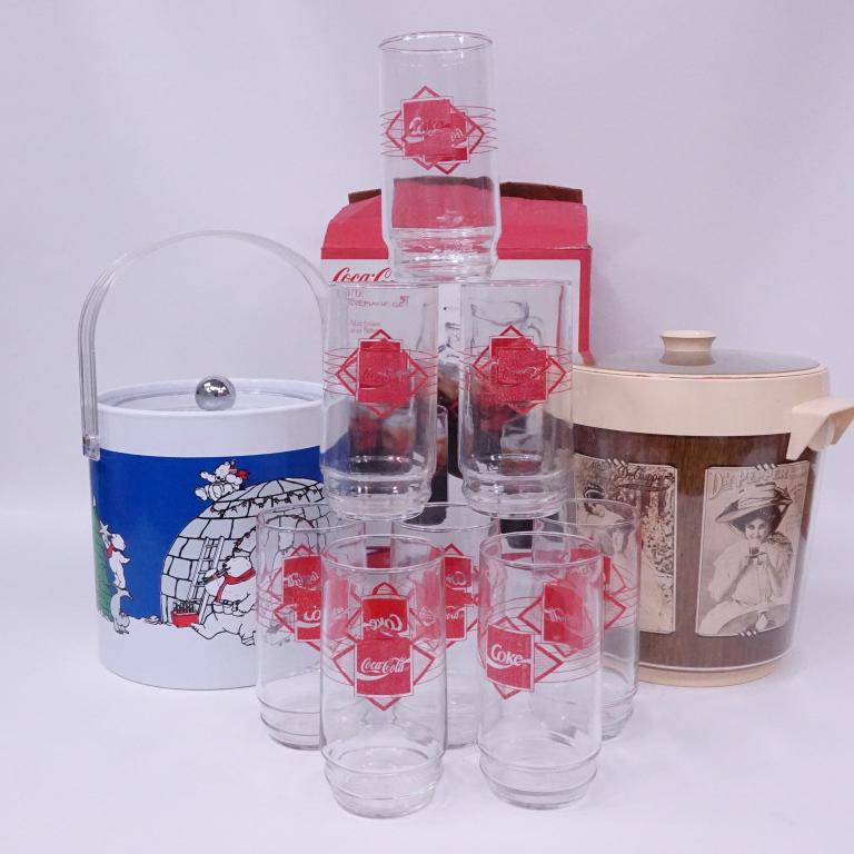 Coca-Cola Glasses and Two Ice Buckets: 8 vintage glasses. 1990's. From Indiana glass. Part of a set. No pitcher. Christmas ice bucket has some wear. Some chips on rim of Dr. Pepper ice bucket.